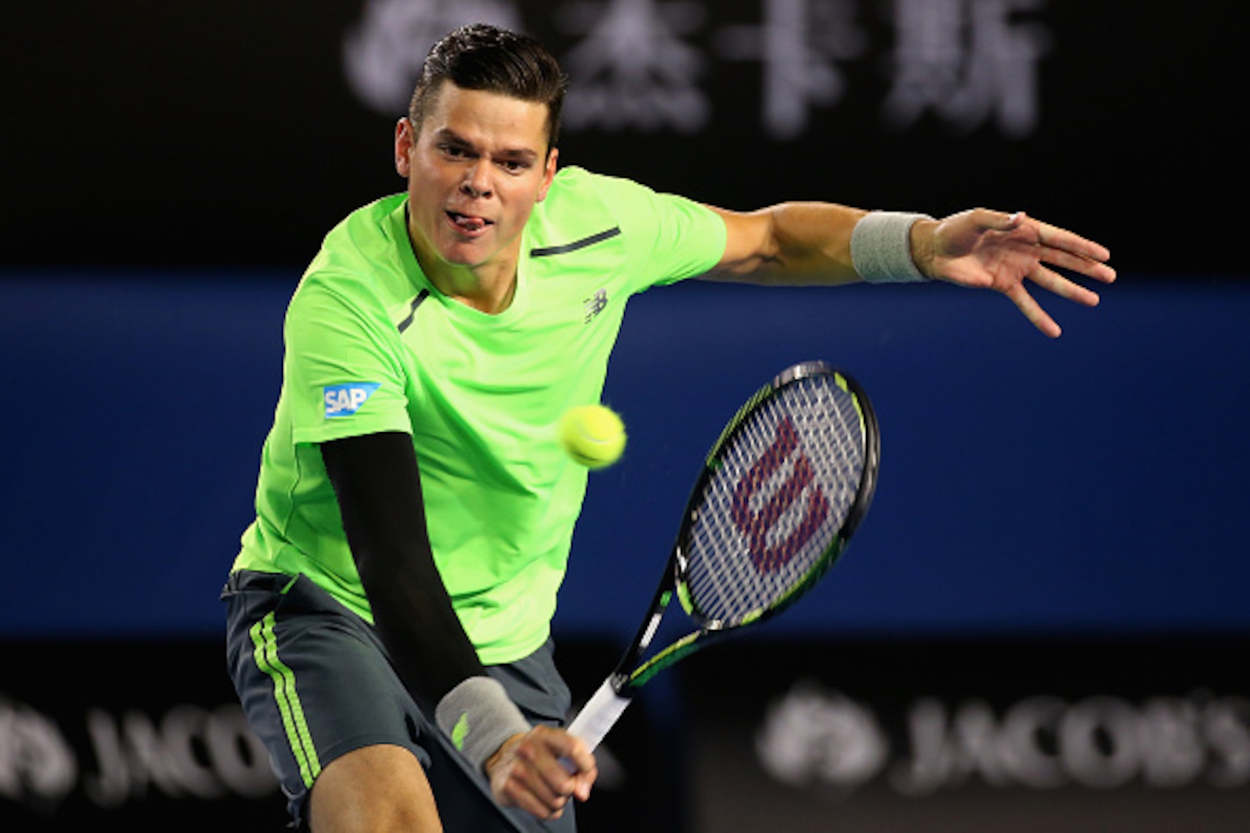 MELBOURNE, AUSTRALIA - JANUARY 28:  Milos Raonic of Canada plays a backhand volley in his quarter final match against Novak Djokovic of Serbia during day 10 of the 2015 Australian Open at Melbourne Park on January 28, 2015 in Melbourne, Australia.  (Photo