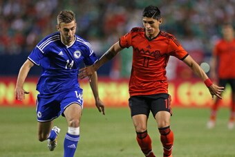CHICAGO, IL - JUNE 03: Alan Pulido #11 of Mexico and Tino Susic #14 of Bosnia & Herzegovina chase down the ball during an international friendly match at Soldier Field on June 3, 2014 in Chicago, Illinois. Bosnia & Herzegovia defeated Mexico 1-0. (Photo b