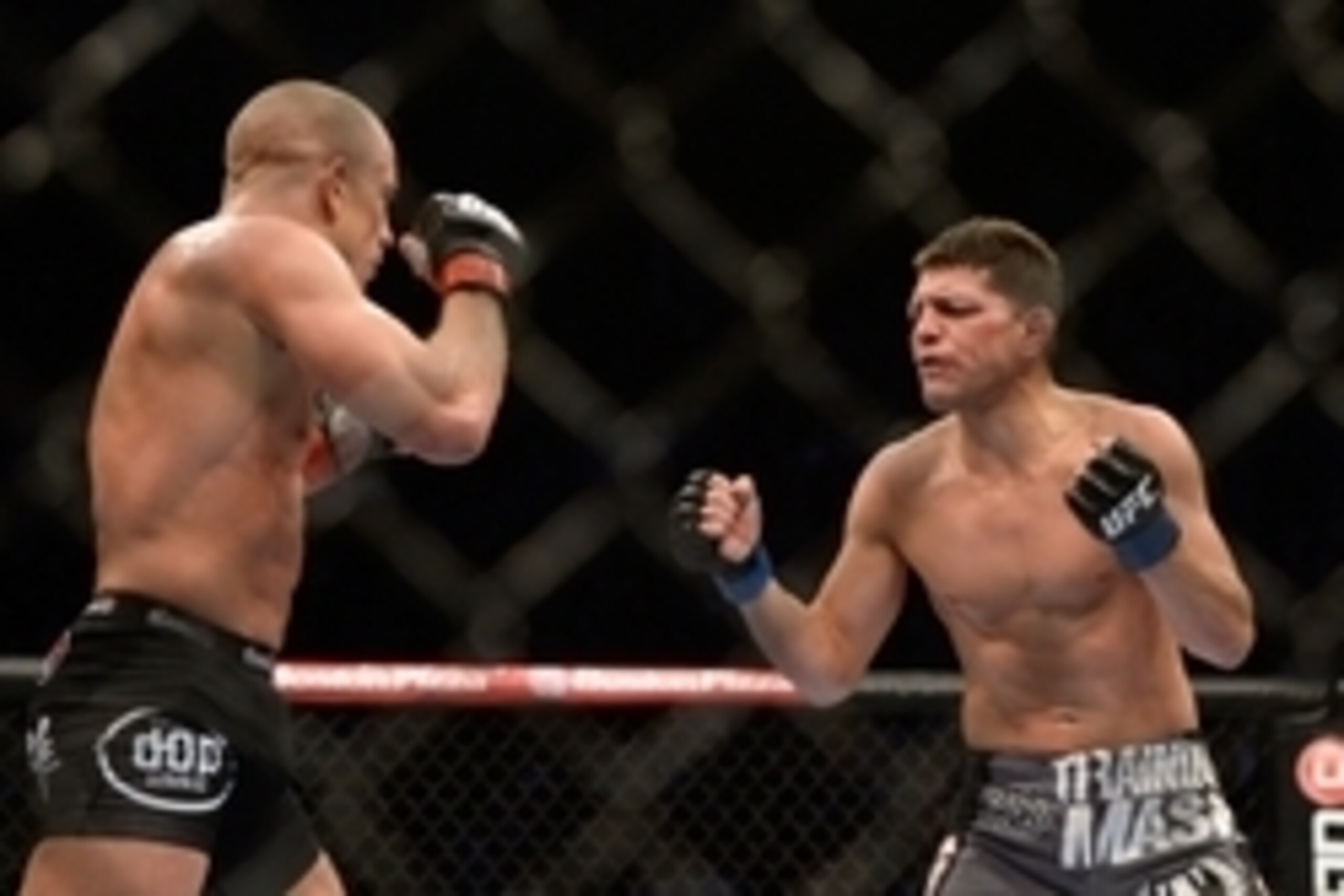 Mar 16, 2013; Montreal, Quebec, CAN;  Nick Diaz (blue) taunts Georges St.Pierre (red) during their Welterweight title bout at UFC 158 at the Bell Centre. Mandatory Credit: Eric Bolte-USA TODAY Sports