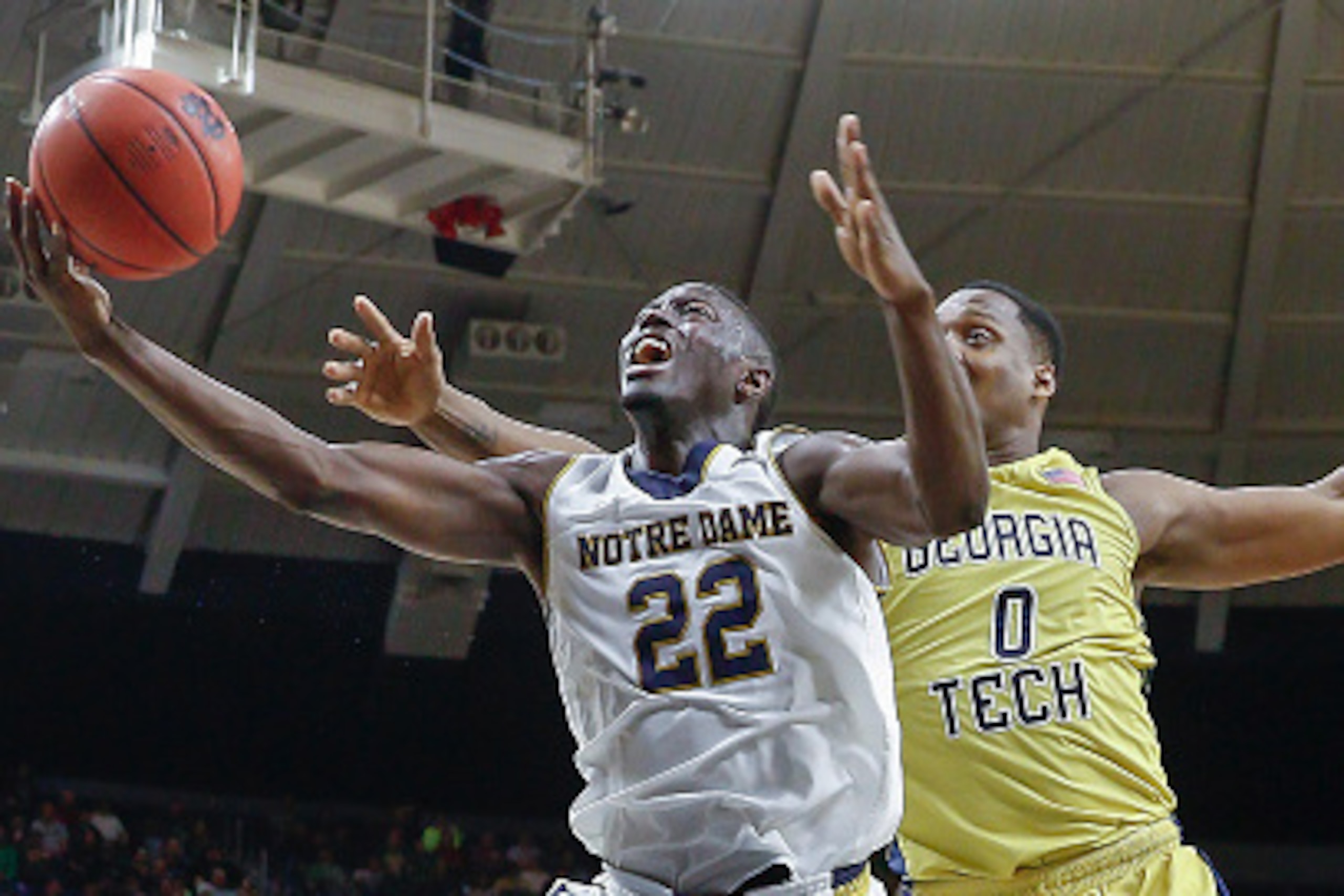 SOUTH BEND, IN - JANUARY 03: Jerian Grant #22 of the Notre Dame Fighting Irish goes to the basket as Charles Mitchell #0 of the Georgia Tech Yellow Jackets defends from behind at Purcell Pavilion on January 3, 2015 in South Bend, Indiana. (Photo by Michae