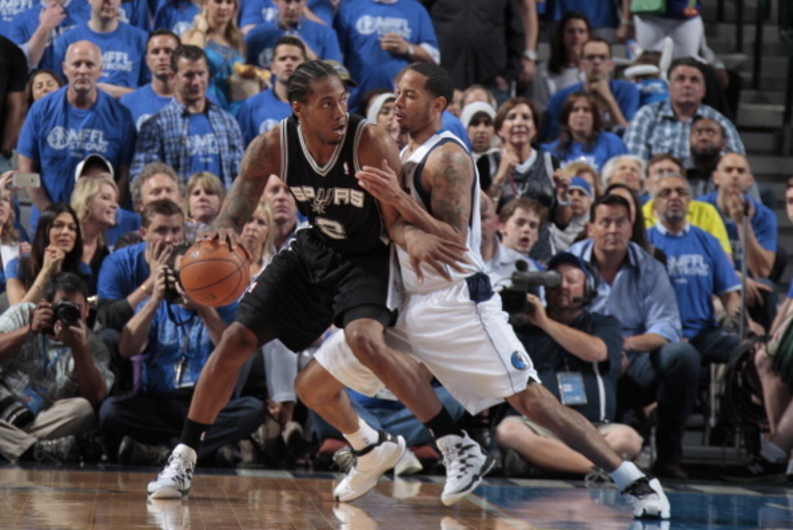 DALLAS, TX - MAY 2: Kawhi Leonard #2 of the San Antonio Spurs posts up against Devin Harris #20 of the Dallas Mavericks during Game Six of the Western Conference Quarterfinals during the 2014 NBA Playoffs on May 2, 2014 at the American Airlines Center in DALLAS, TX - MAY 2: Kawhi Leonard #2 of the San Antonio Spurs posts up against Devin Harris #20 of the Dallas Mavericks during Game Six of the Western Conference Quarterfinals during the 2014 NBA Playoffs on May 2, 2014 at the American Airlines Center in