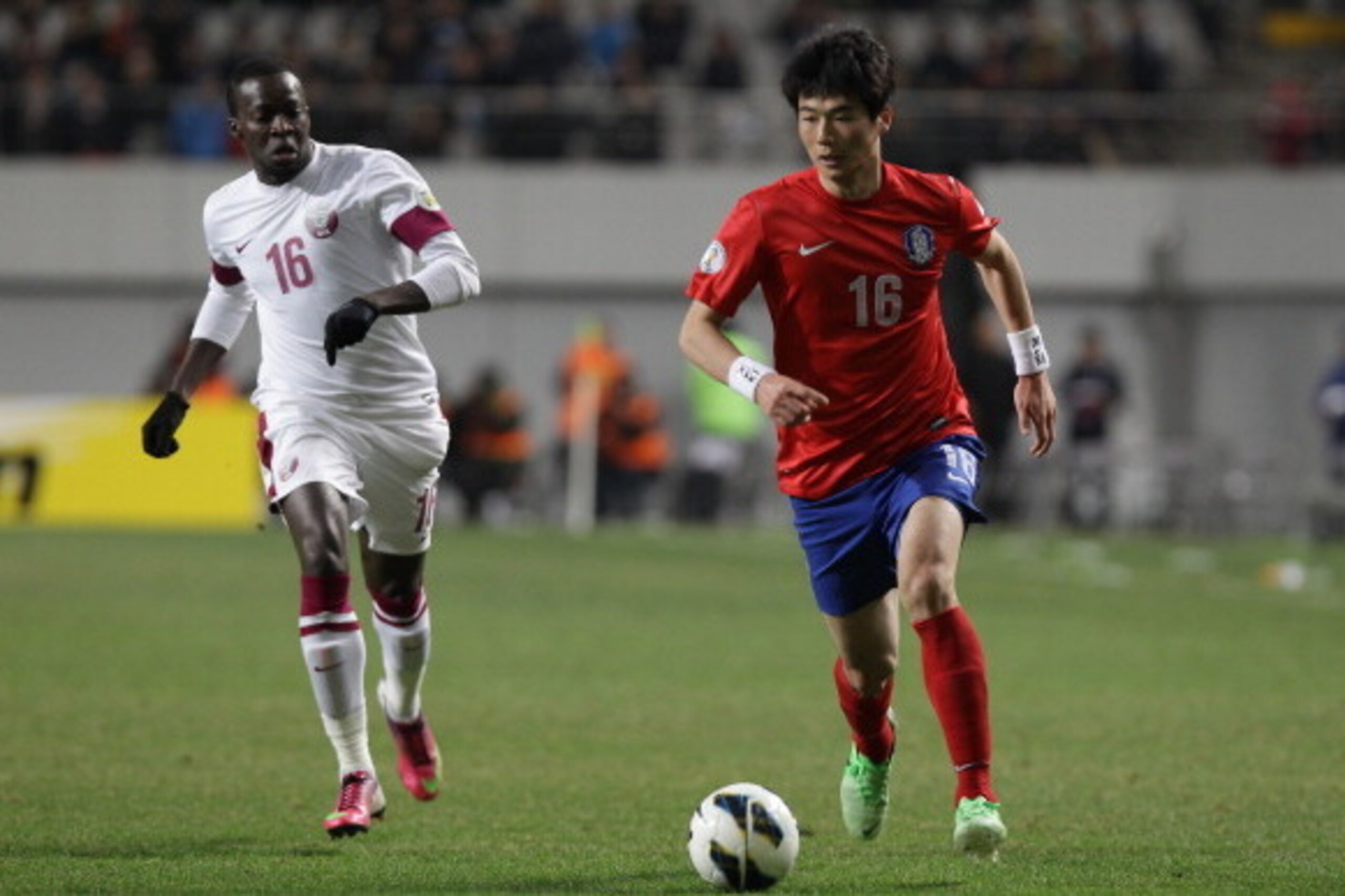 SEOUL, SOUTH KOREA - MARCH 26:  Ki Sung-Yeung of South Korea tussles for possession with Maher Yousef of Qatar during the FIFA World Cup Qualifier match between South Korea and Qatar at Olympic Stadium on March 26, 2013 in Seoul, South Korea.  (Photo by C