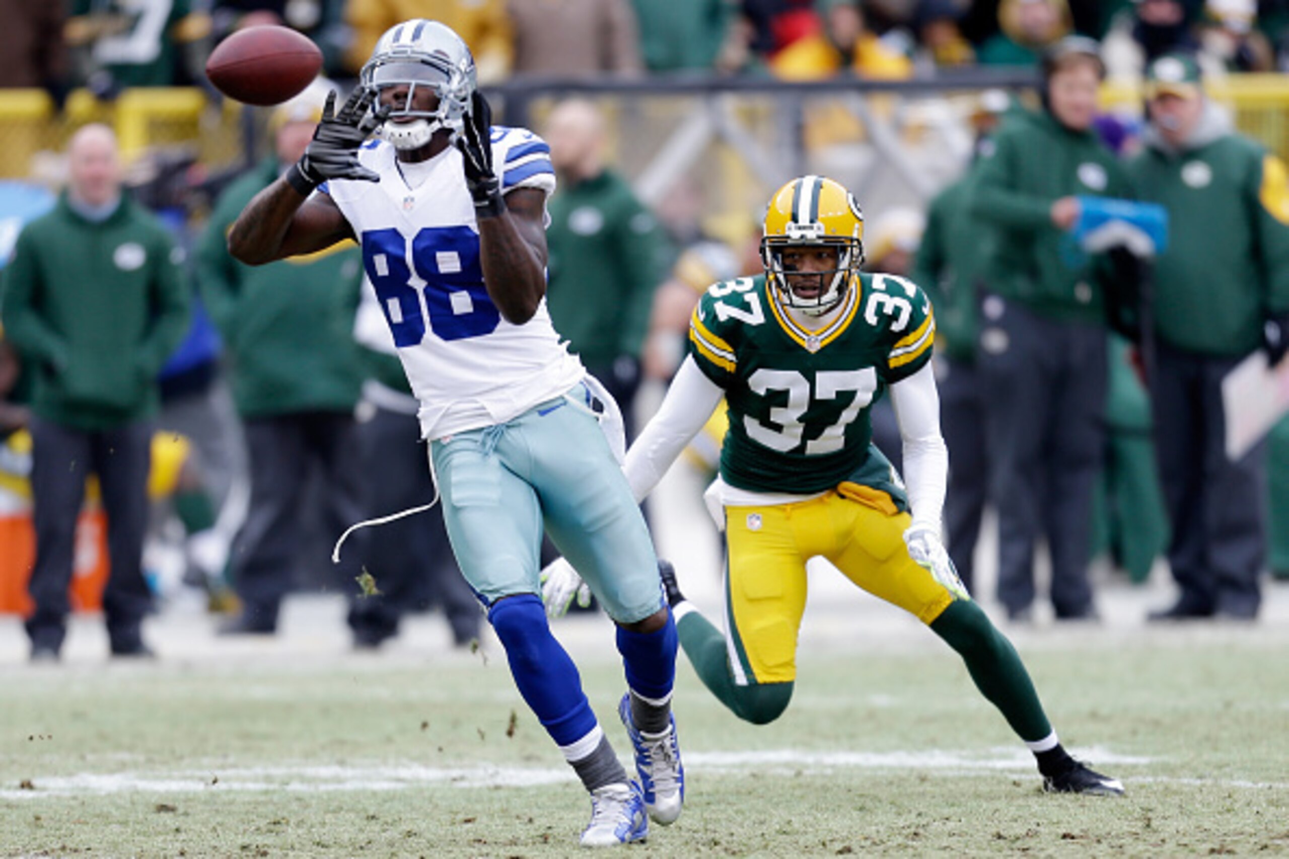 GREEN BAY, WI - JANUARY 11:   Dez Bryant #88 of the Dallas Cowboys receives a pass ahead of  Sam Shields #37 of the Green Bay Packers in the third quarter during the 2015 NFC Divisional Playoff game at Lambeau Field on January 11, 2015 in Green Bay, Wisco