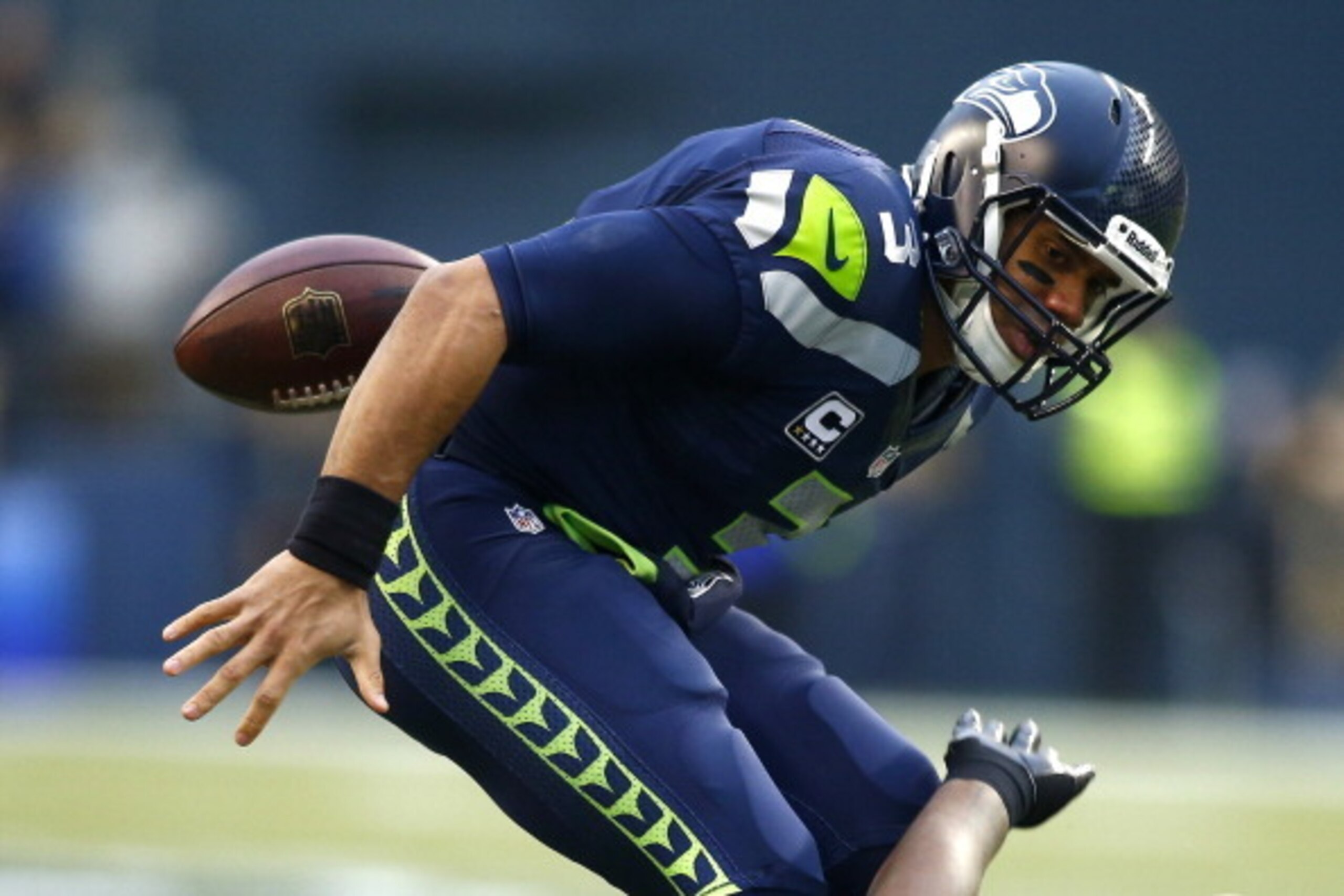 SEATTLE, WA - JANUARY 19: Quarterback Russell Wilson #3 of the Seattle Seahawks fumbles the ball in the first quarter after being tackled by outside linebacker Aldon Smith #99 of the San Francisco 49ers during the 2014 NFC Championship at CenturyLink Fiel