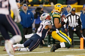 GREEN BAY, WI - NOVEMBER 30:  Tight end Richard Rodgers #89 of the Green Bay Packers scores a touchdown on a 32 yard pass form Aaron Rodgers #12 as strong safety Patrick Chung #23 of the New England Patriots holds on behind in the first quarter during the