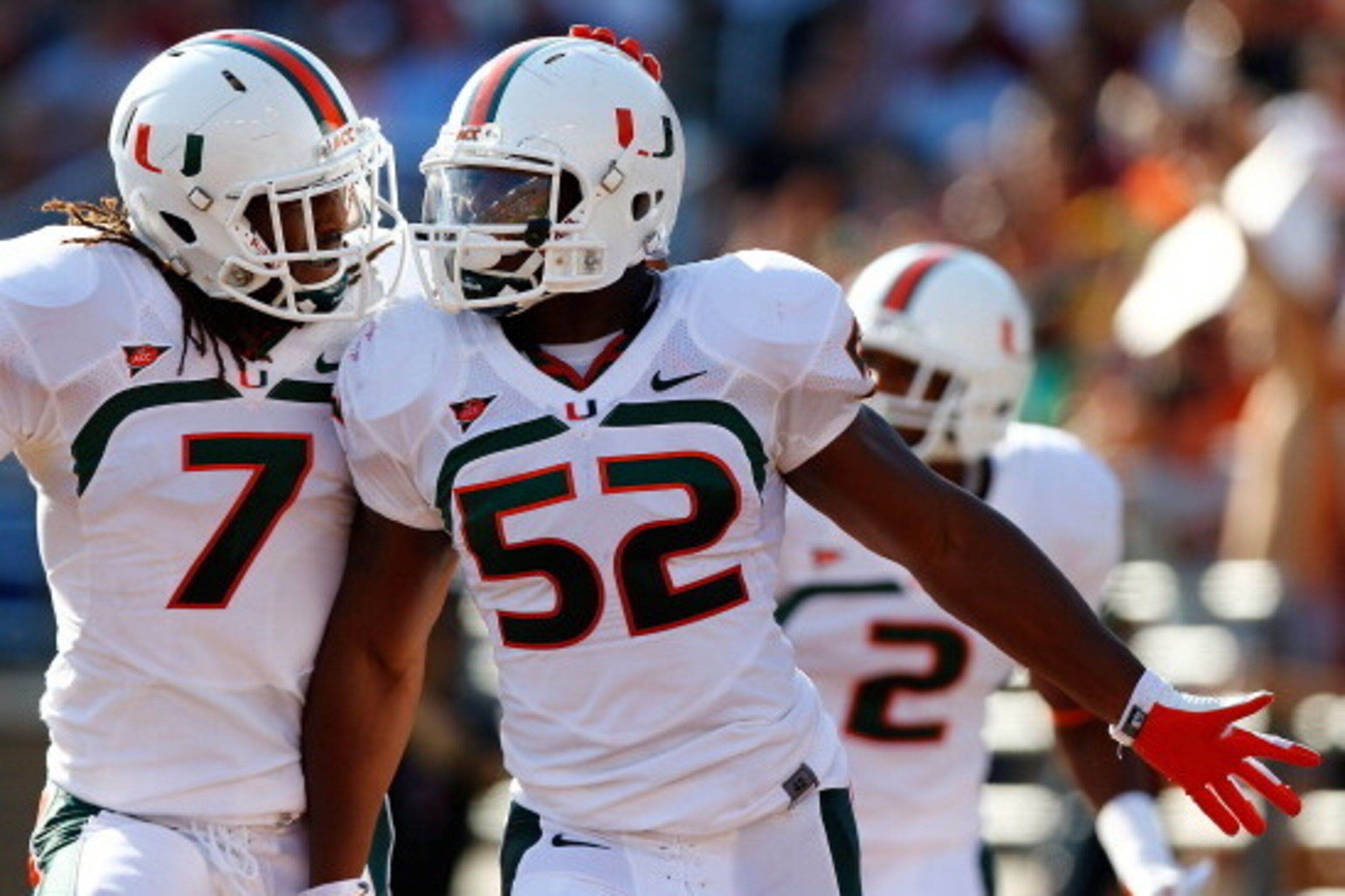 CHESTNUT HILL, MA - SEPTEMBER 01:  Denzel Perryman #52 of the Miami Hurricanes is congratulated by teammate Vaughn Telemaque #7 after scoring a touchdown on a returned interception against the Boston College Eagles during the game on September 1, 2012 at 