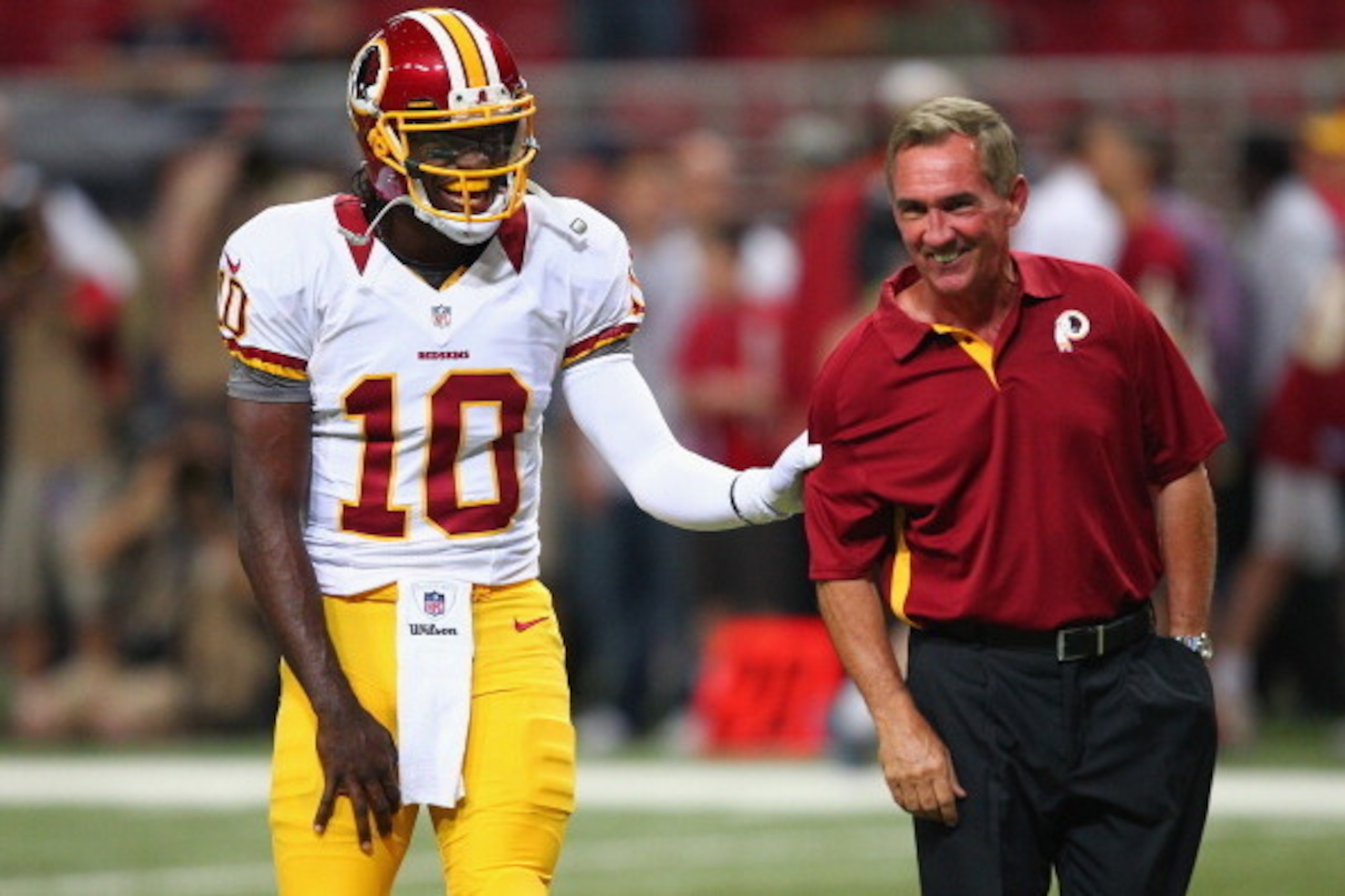 ST. LOUIS, MO - SEPTEMBER 16: Robert Griffin III #10 of the Washington Redskins jokes with head coach Mike Shanahan also of the Washington Redskins during pre-game warm ups prior to playing against the St. Louis Rams at the Edward Jones Dome on September 