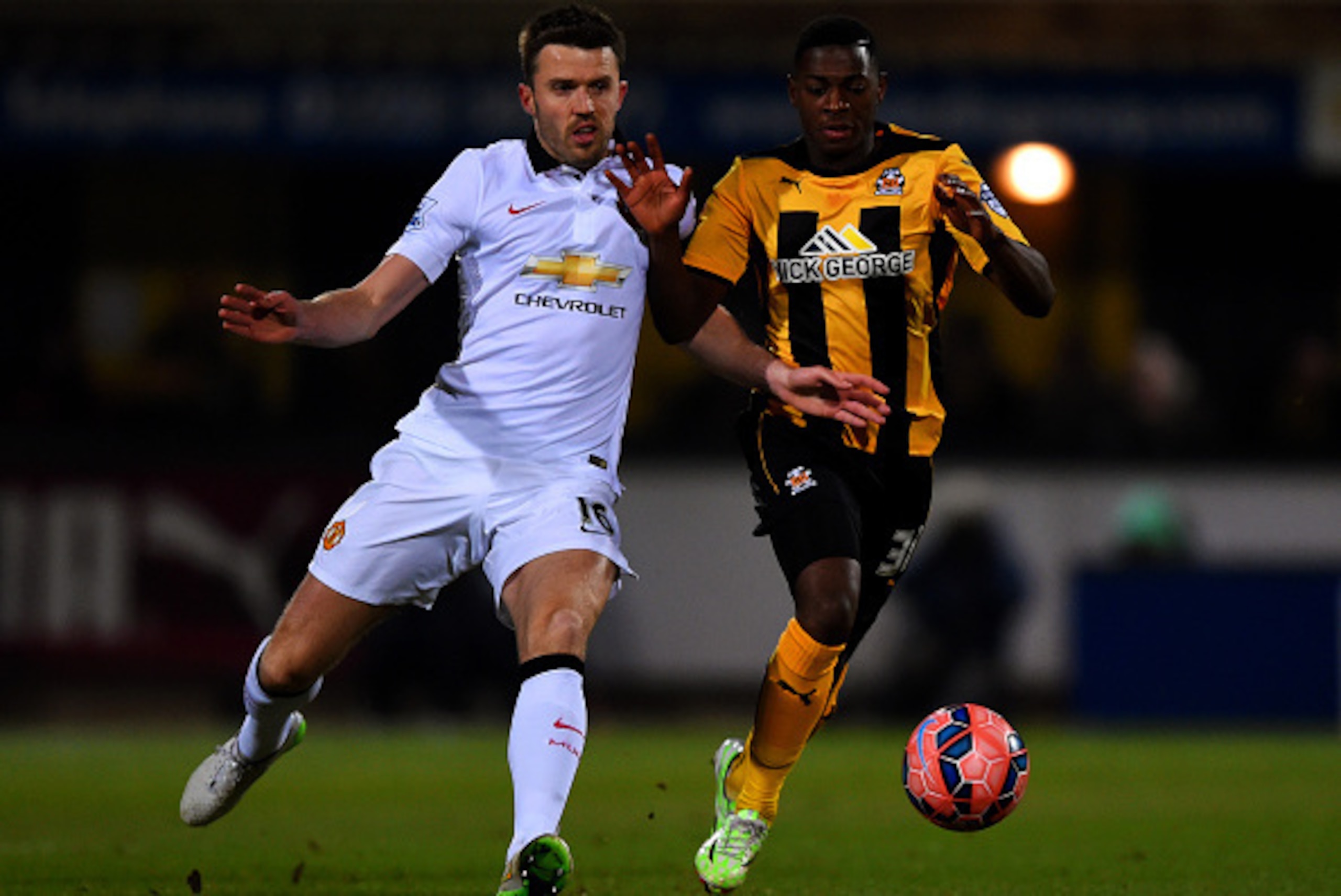 CAMBRIDGE, ENGLAND - JANUARY 23: Sullay Kaikai of Cambridge United battles for the ball with Michael Carrick of Manchester United during the FA Cup Fourth Round match between Cambridge United and Manchester United at The R Costings Abbey Stadium on Janua CAMBRIDGE, ENGLAND - JANUARY 23: Sullay Kaikai of Cambridge United battles for the ball with Michael Carrick of Manchester United during the FA Cup Fourth Round match between Cambridge United and Manchester United at The R Costings Abbey Stadium on Janua