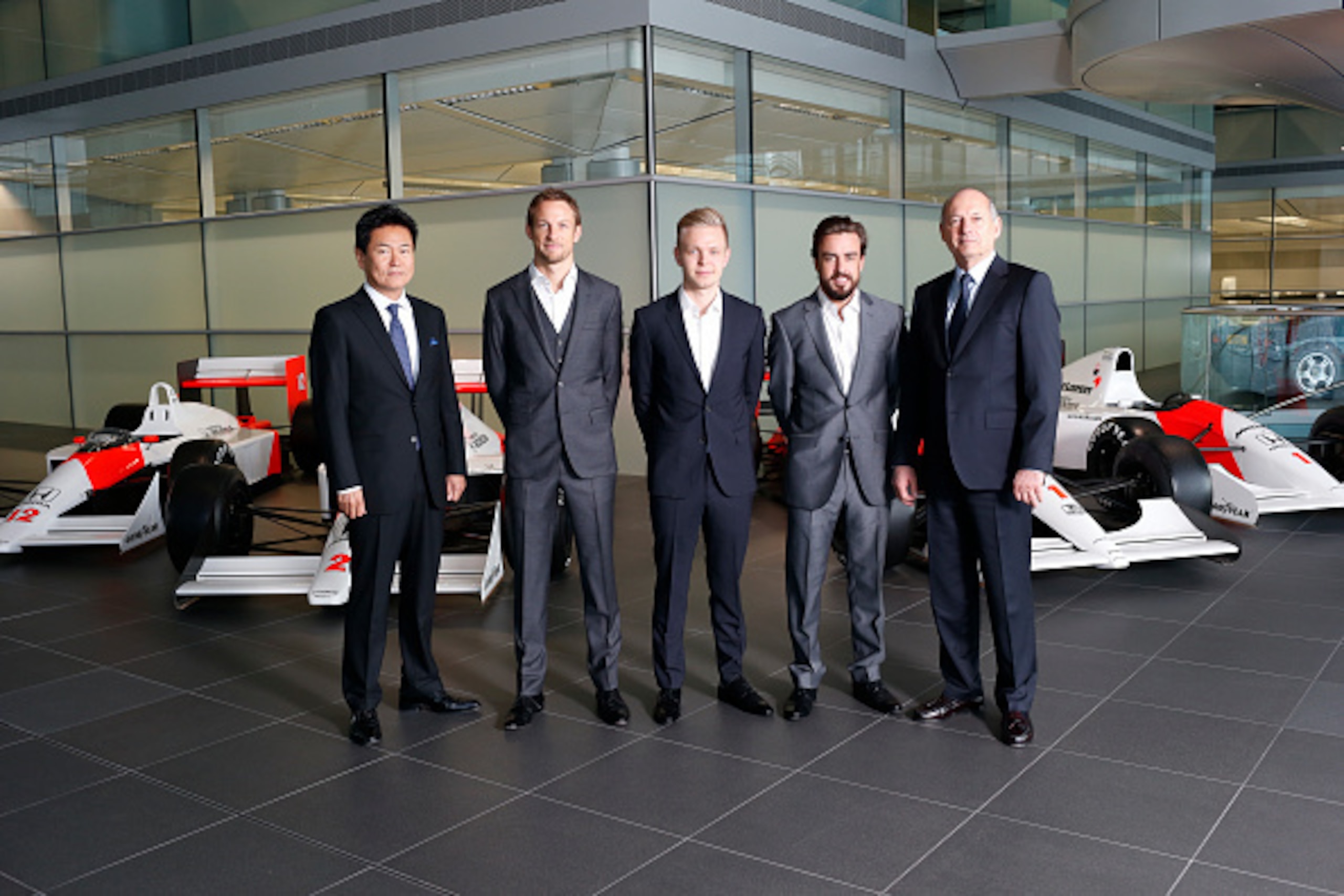 WOKING, ENGLAND- DECEMBER 10: In this handout photo provided by McLaren-Honda, Formula One drivers Fernando Alonso (2nd R) and Jenson Button (2nd L) pose as McLaren-Honda announces its new driver line-up for 2015 with Kevin Magnussen (C) who will remain a