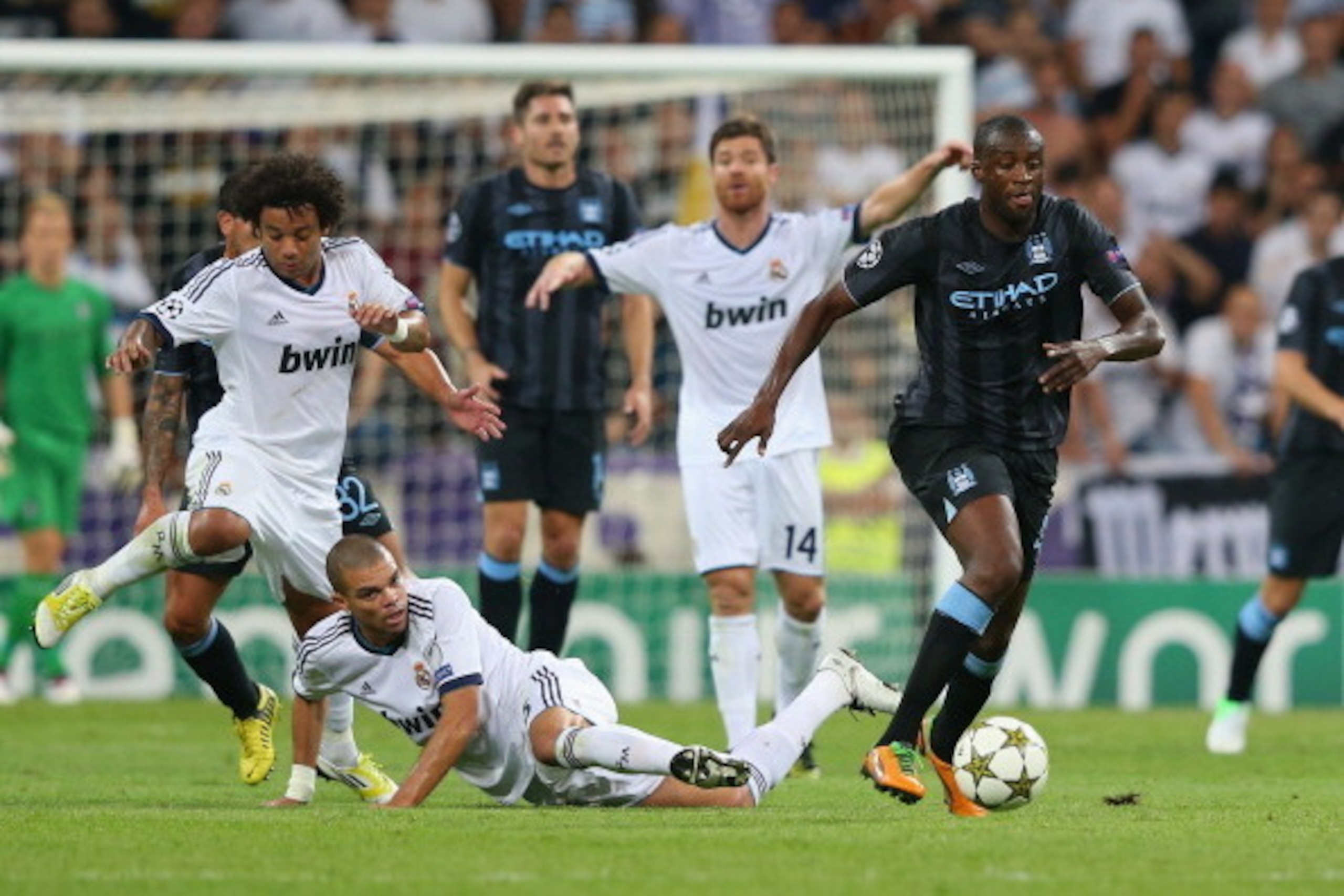 MADRID, SPAIN - SEPTEMBER 18:  Yaya Toure of Manchester City FC beats Pepe of Real Madrid on his way to setting up the first goal during the  UEFA Champions League Group D match between Real Madrid and Manchester City FC at Estadio Santiago Bernabeu on Se