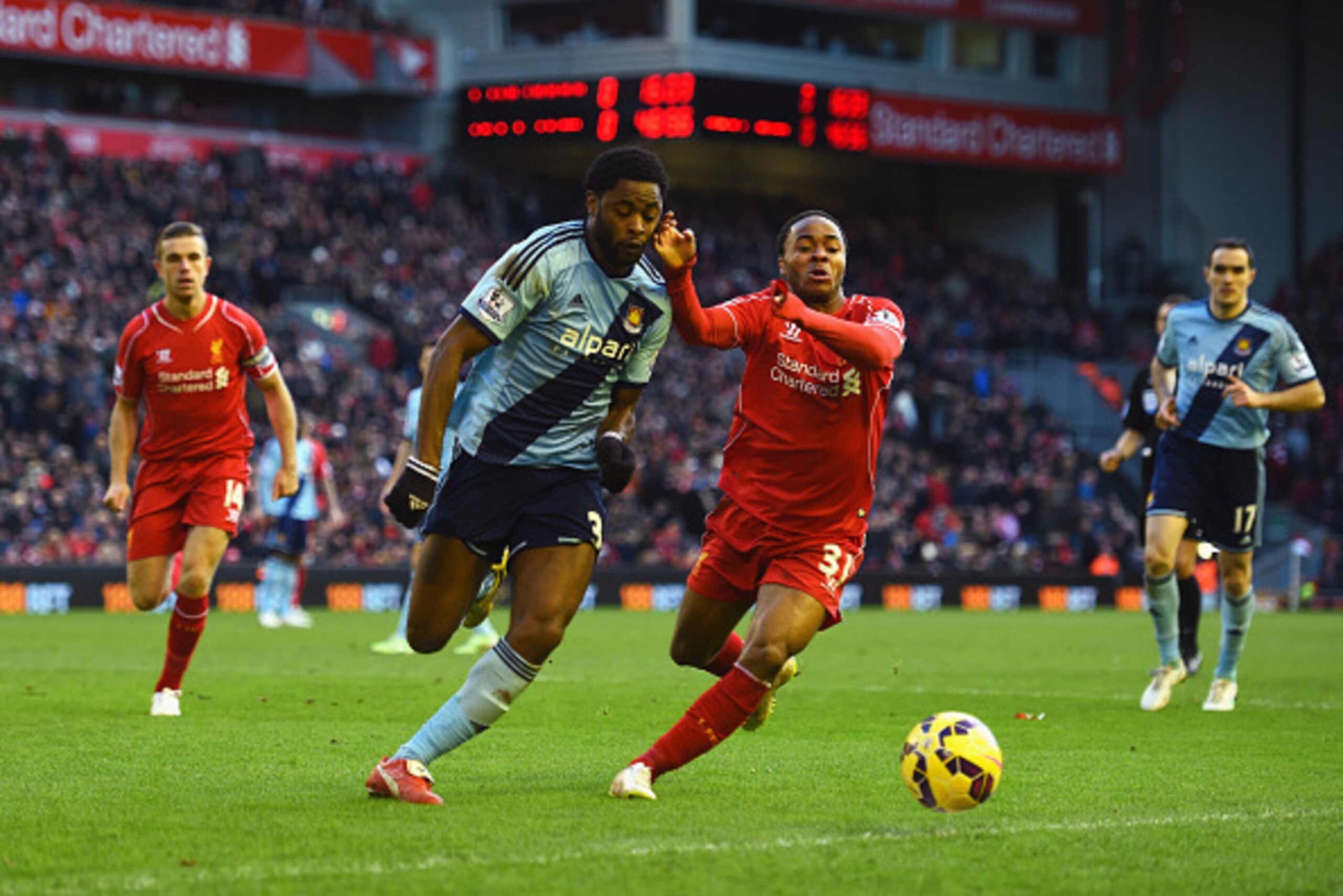 LIVERPOOL, ENGLAND - JANUARY 31: Alexandre Song of West Ham United is challenged by Raheem Sterling of Liverpool during the Barclays Premier League match between Liverpool and West Ham United at Anfield on January 31, 2015 in Liverpool, England.  (Photo b