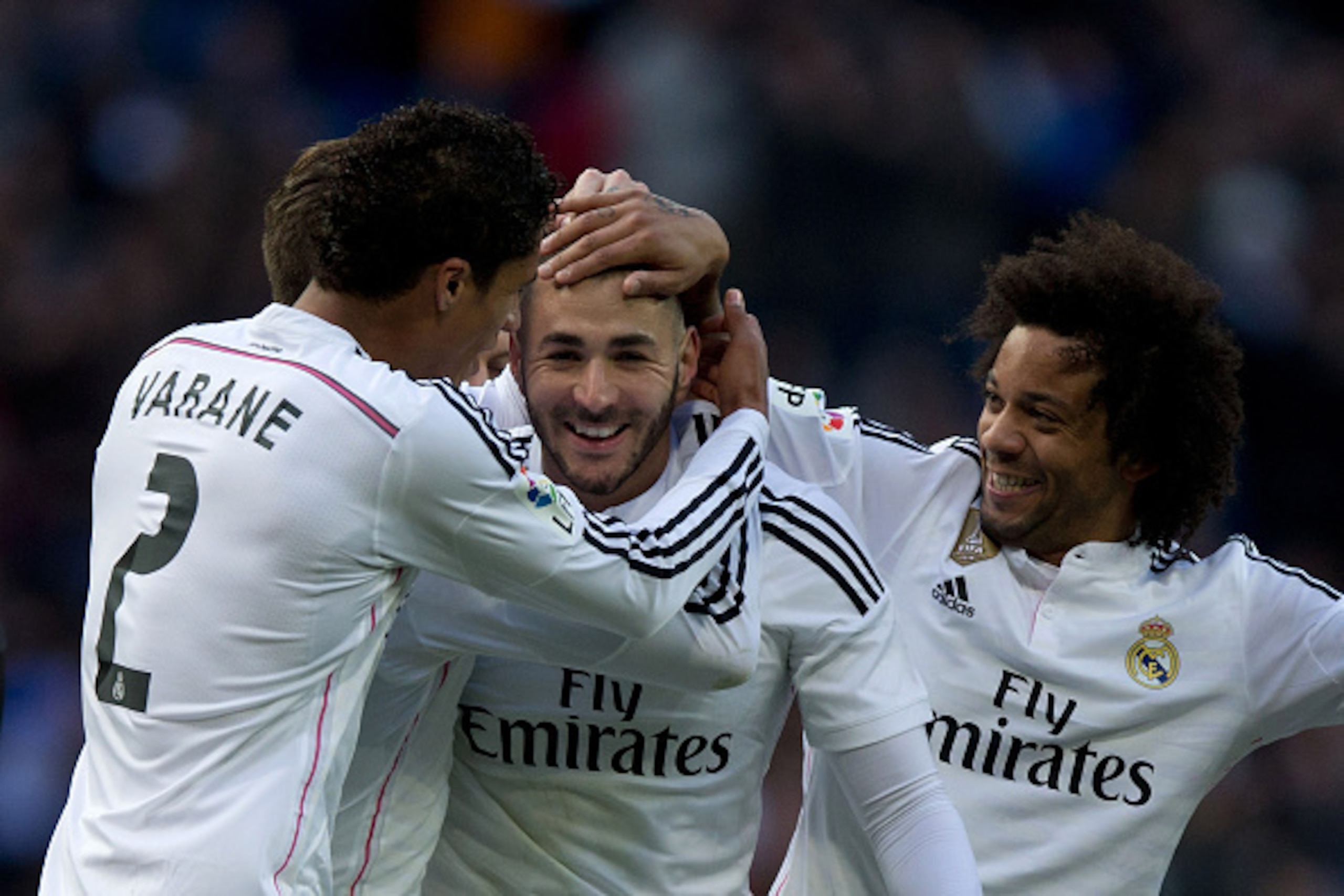 MADRID, SPAIN - JANUARY 31:  Karim Benzema (2nd L) of Real Madrid CF celebrates scoring their fourth goal with team-mates Raphael Varane (L) and Marcelo (R) during the La Liga match between Real Madrid CF and Real Sociedad de Futbol at Estadio Santiago Be