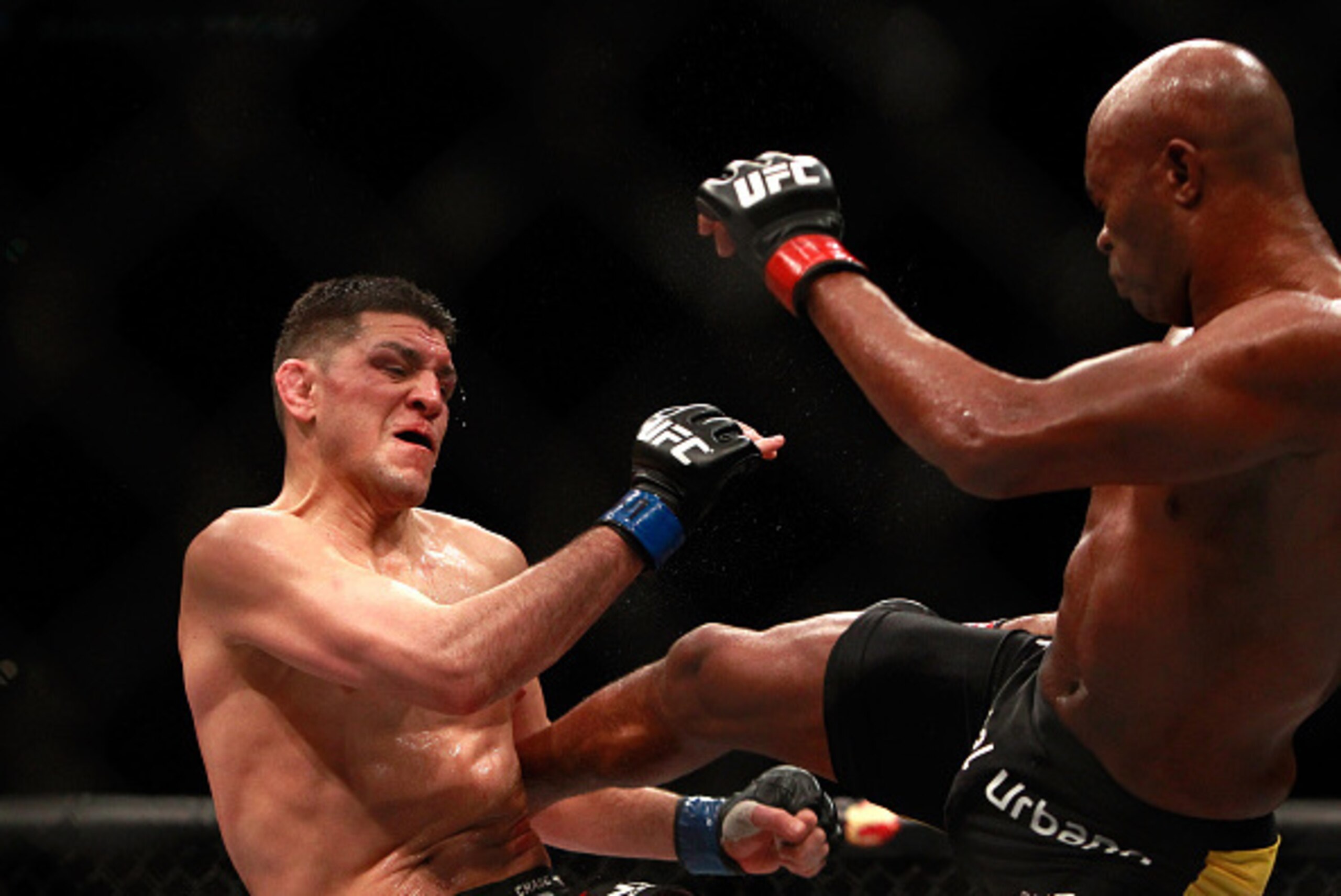 LAS VEGAS, NV - JANUARY 31:  Nick Diaz (L) takes a kick from Anderson Silva in a middleweight bout during UFC 183 at the MGM Grand Garden Arena on January 31, 2015 in Las Vegas, Nevada. Silva won by unanimous decision.  (Photo by Steve Marcus/Getty Images