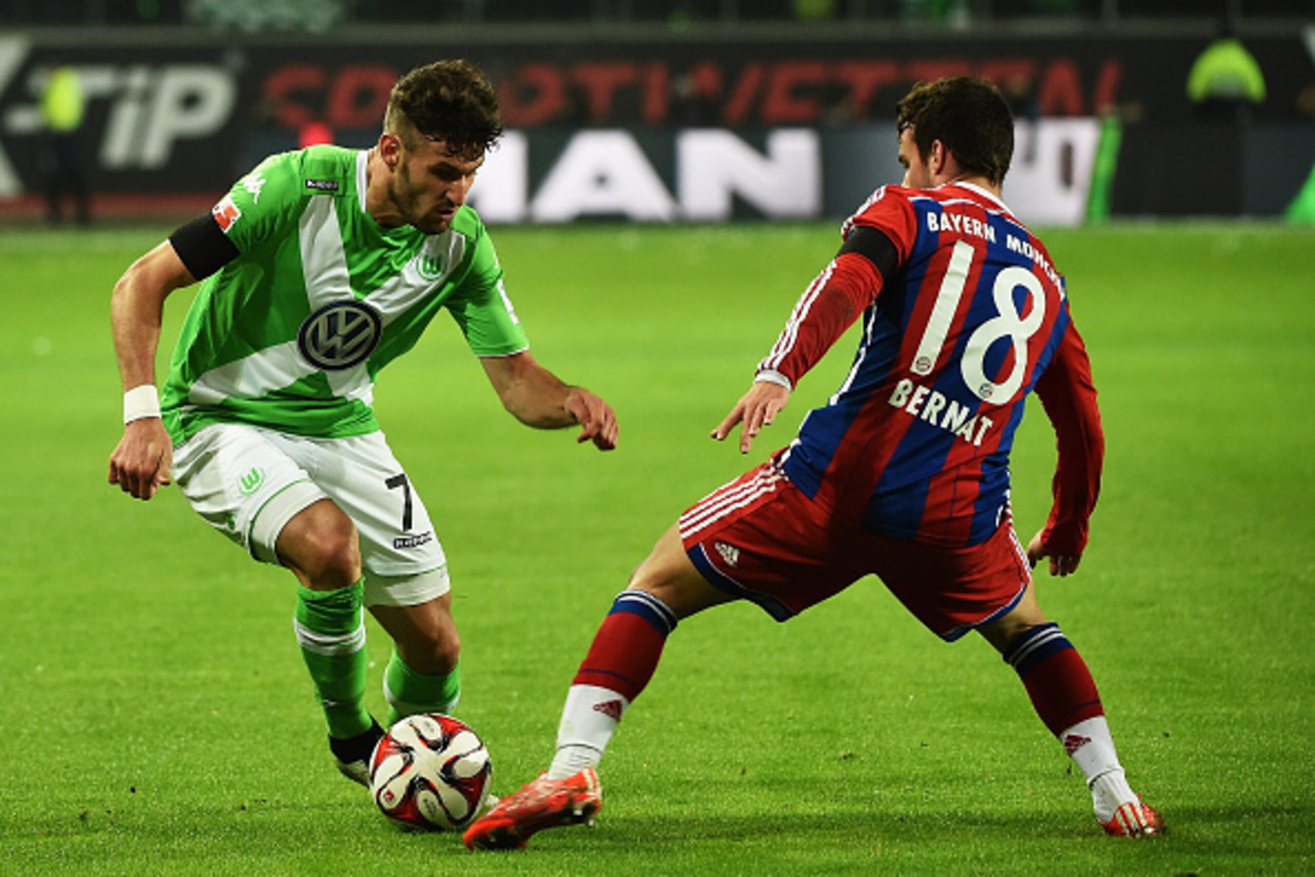 WOLFSBURG, GERMANY - JANUARY 30:  Juan Bernat  of Muenchen is challenged by Daniel Caligiuri of Wolfsburg during the Bundesliga match between VfL Wolfsburg and FC Bayern Muenchen at Volkswagen Arena on January 30, 2015 in Wolfsburg, Germany.  (Photo by St