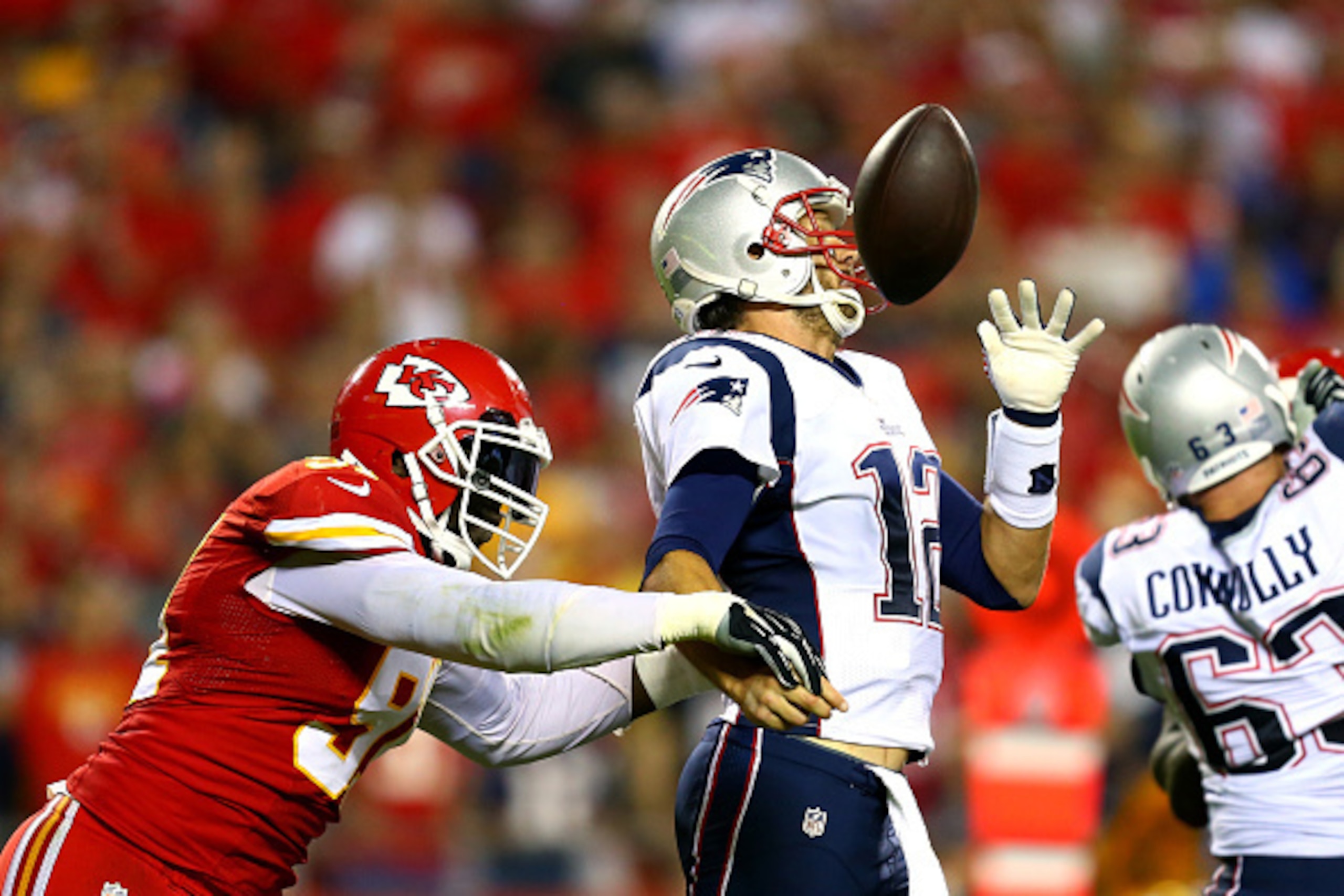 KANSAS CITY, MO - SEPTEMBER 29:  Tamba Hali #91 of the Kansas City Chiefs knocks the ball loose from Tom Brady #12 of the New England Patriots for a fumble during the third quarter at Arrowhead Stadium on September 29, 2014 in Kansas City, Missouri.  (Pho