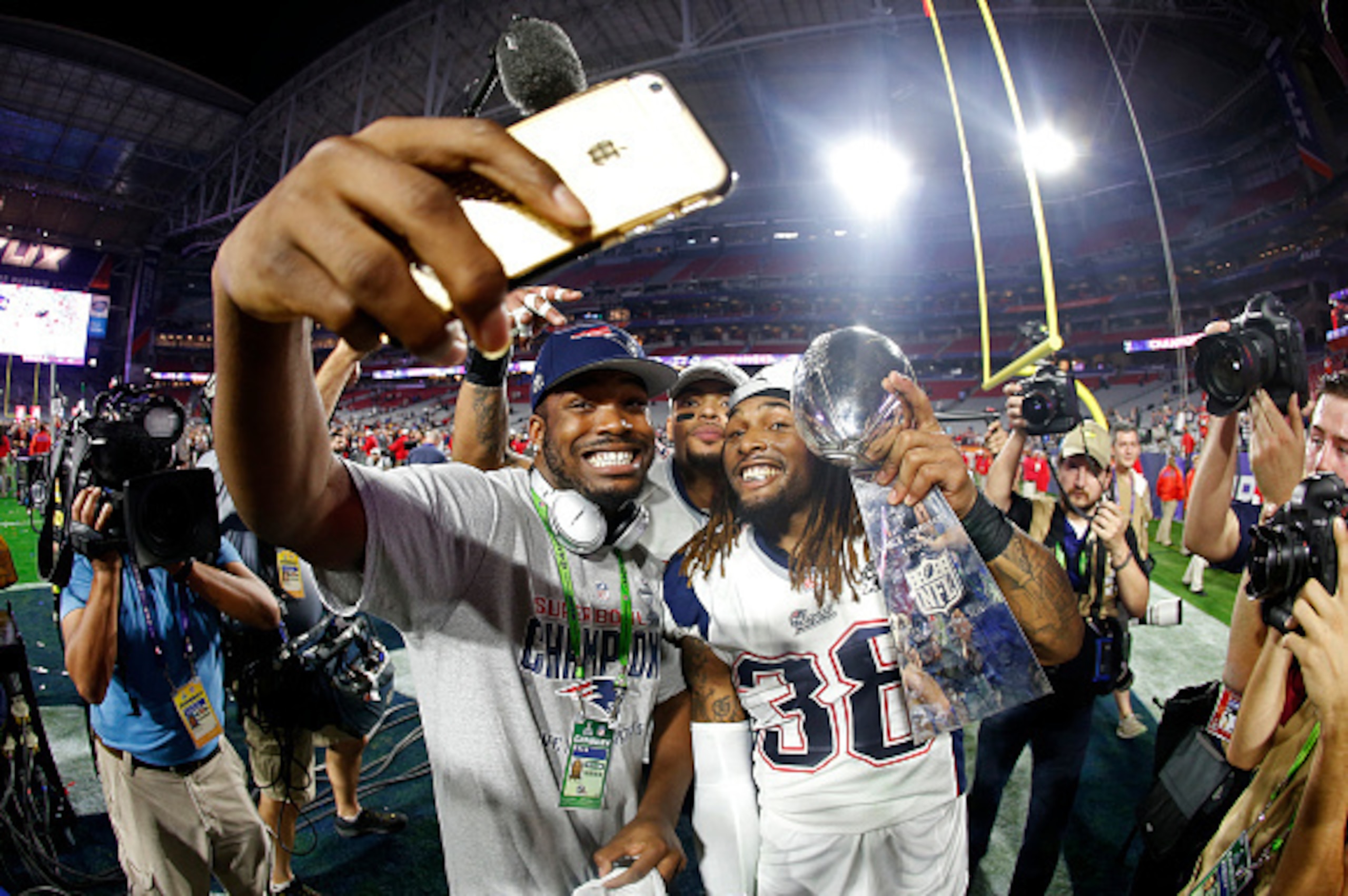 GLENDALE, AZ - FEBRUARY 01:  Members of the New England Patriots celebrate with the Vince Lombardi Trophy after defeating the Seattle Seahawks 28-24 in Super Bowl XLIX at University of Phoenix Stadium on February 1, 2015 in Glendale, Arizona.  (Photo by C