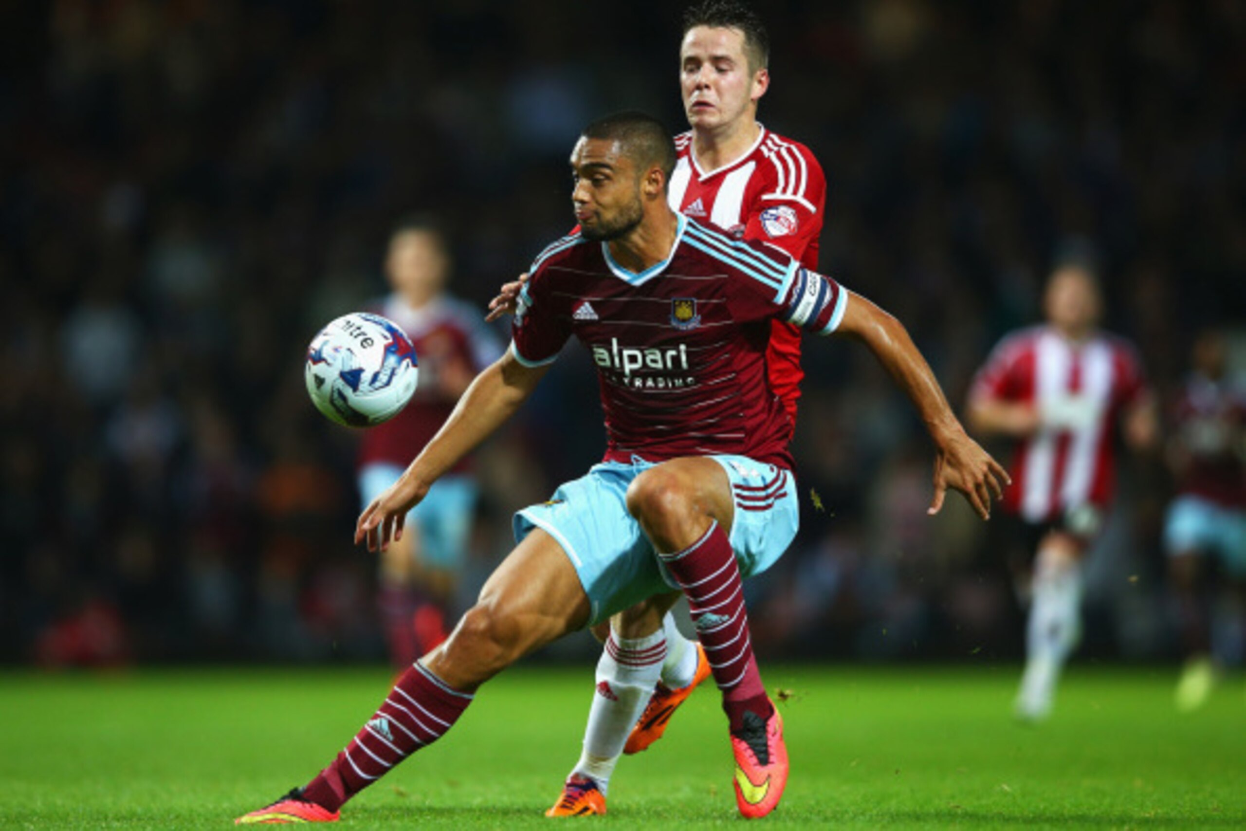 LONDON, ENGLAND - AUGUST 26: Winston Reid of West Ham United is challenged by Marc McNulty of Sheffield United during the Capital One Cup Second Round match between West Ham United and Sheffield United at Boleyn Ground on August 26, 2014 in London, Englan