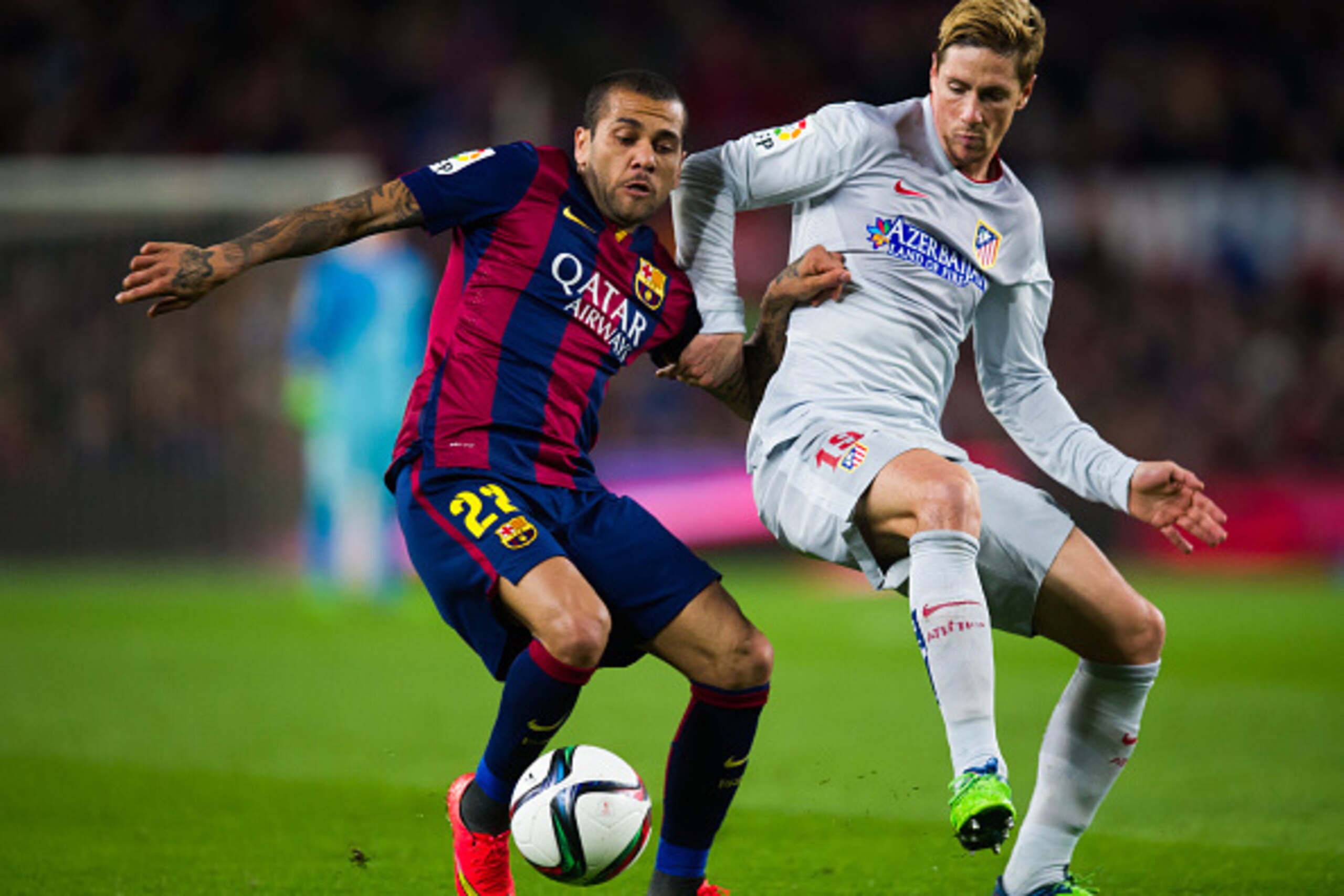 BARCELONA, SPAIN - JANUARY 21:  Dani Alves of FC Barcelona fights for the ball with Fernando Torres of Club Atletico de Madrid during the Copa del Rey Quarter-Final First Leg match between FC Barcelona and Club Atletico de Madrid at Camp Nou on January 21