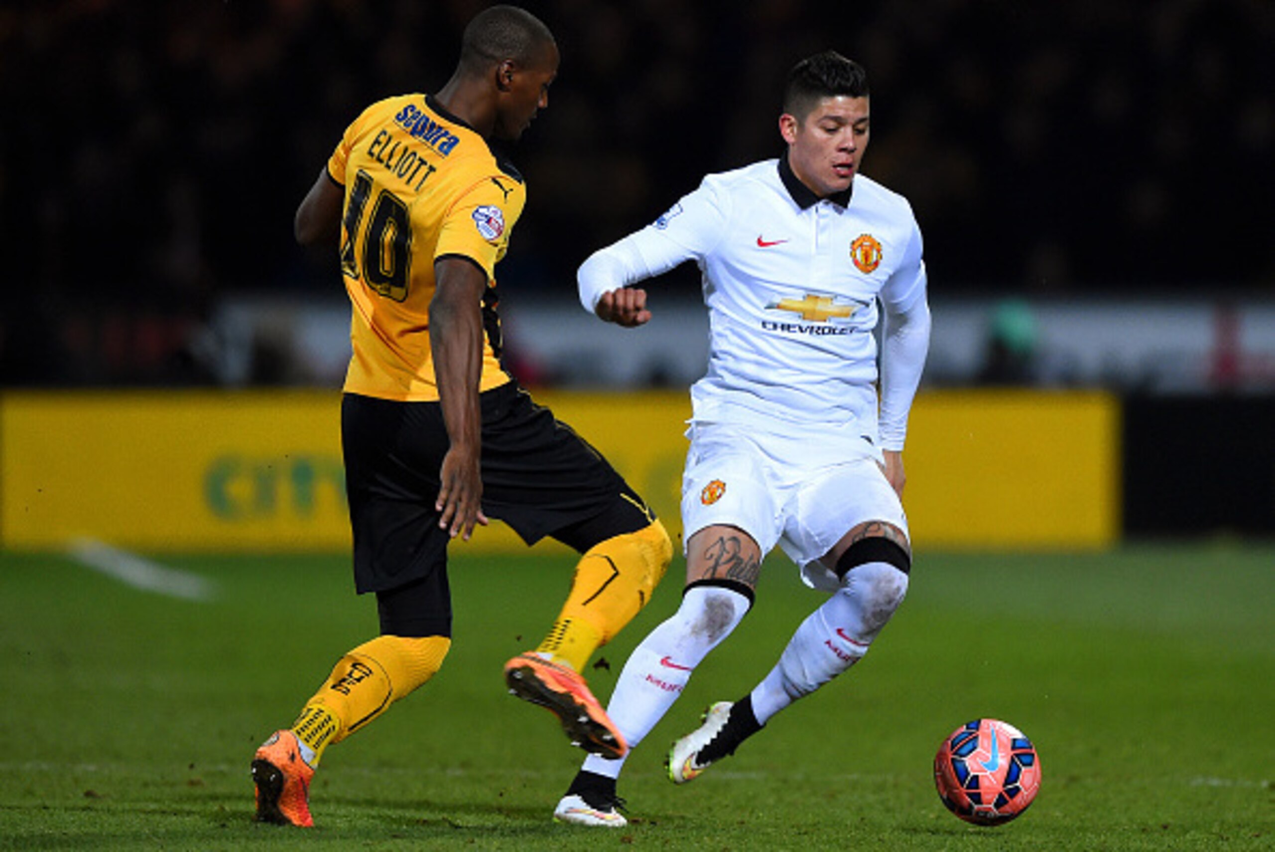 CAMBRIDGE, ENGLAND - JANUARY 23:  Marcos Rojo of Manchester United battles for the ball with Tom Elliott of Cambridge United during the FA Cup Fourth Round match between Cambridge United and Manchester United at The R Costings Abbey Stadium on January 23,