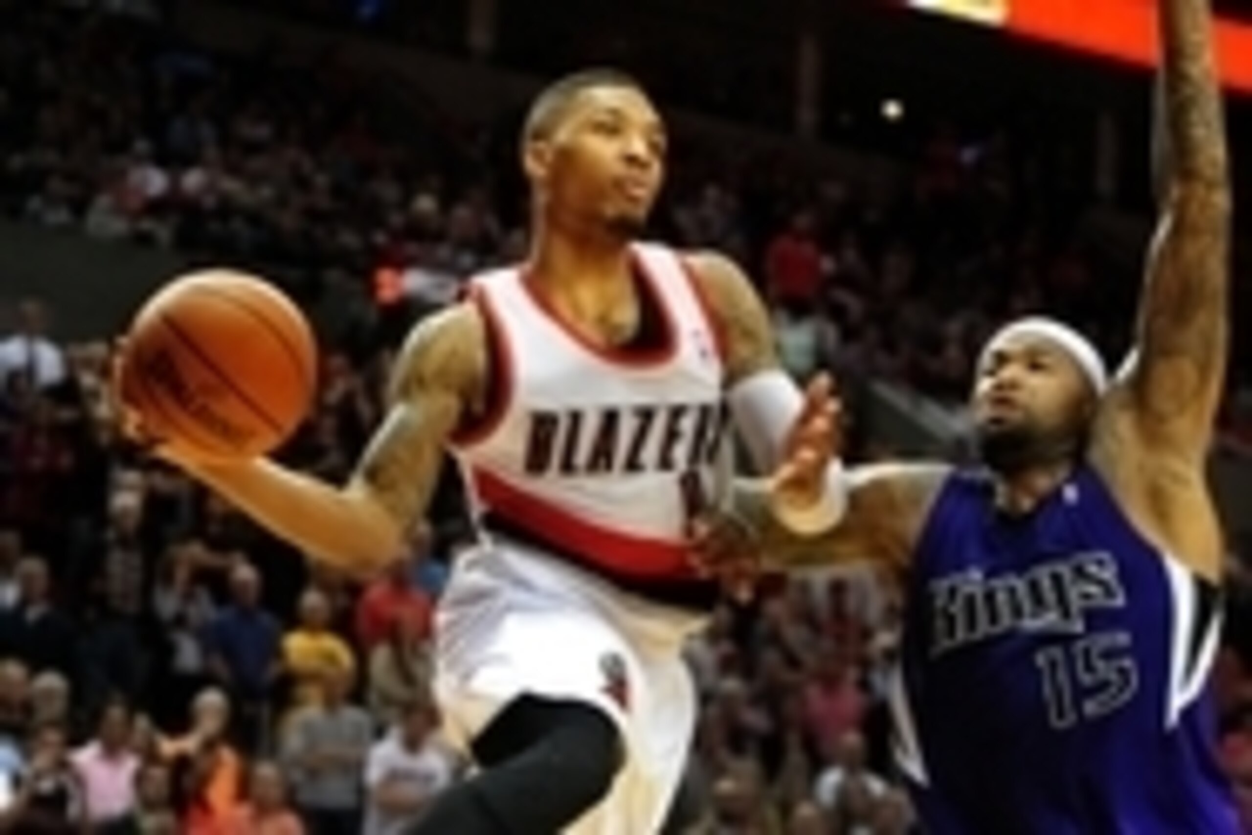 Apr 9, 2014; Portland, OR, USA; Portland Trail Blazers guard Damian Lillard (0) passes the ball as Sacramento Kings center DeMarcus Cousins (15) defends late in the fourth quarter of the game at Moda Center. The Blazers won 100- 99. Mandatory Credit: Stev
