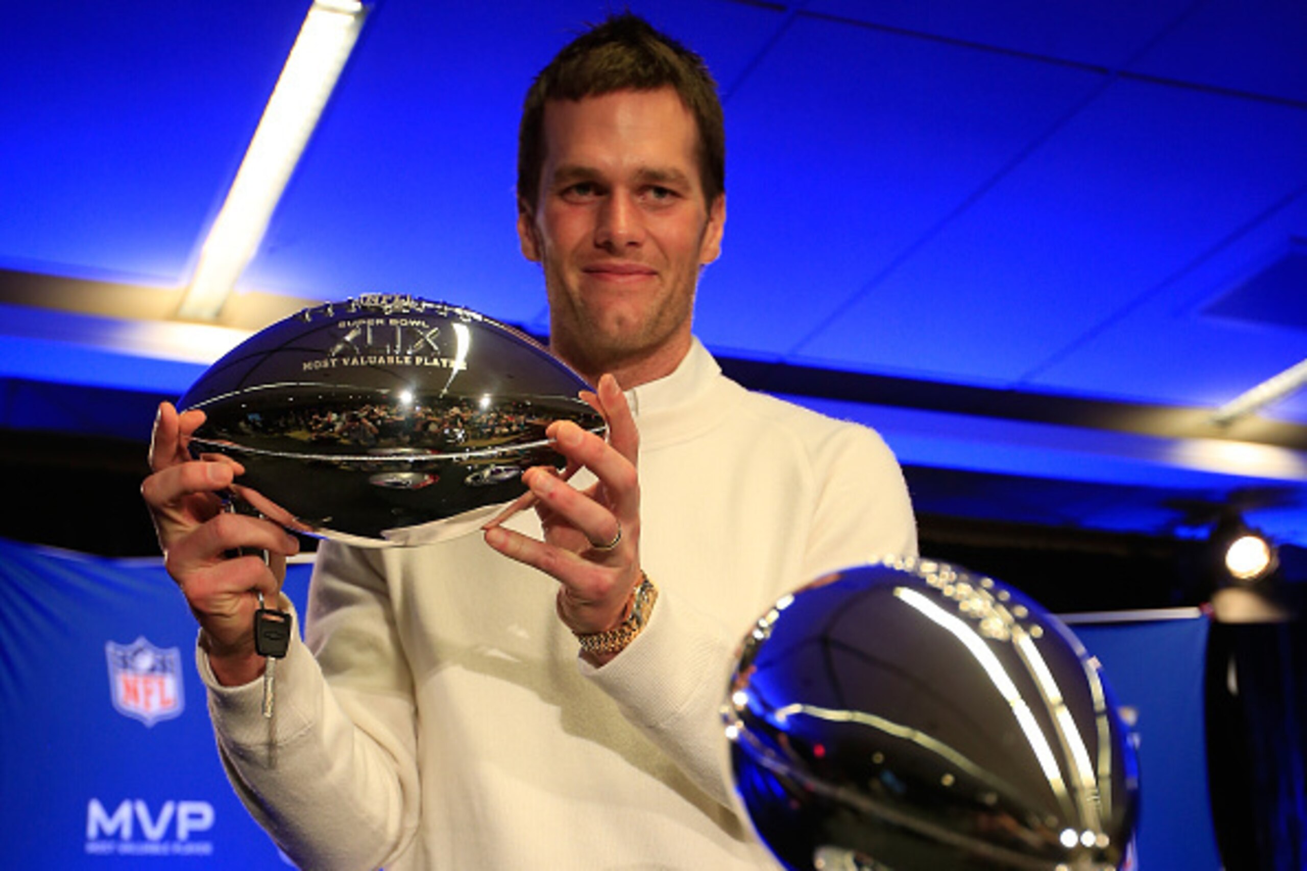 PHOENIX, AZ - FEBRUARY 02:  (L-R) Tom Brady of the New England Patriots holds the Super Bowl XLIX MVP trophy during a Chevrolet Super Bowl XLIX MVP press conference folowing the Patriots Super Bowl win over the Seattle Seahawks on February 2, 2015 in Phoe