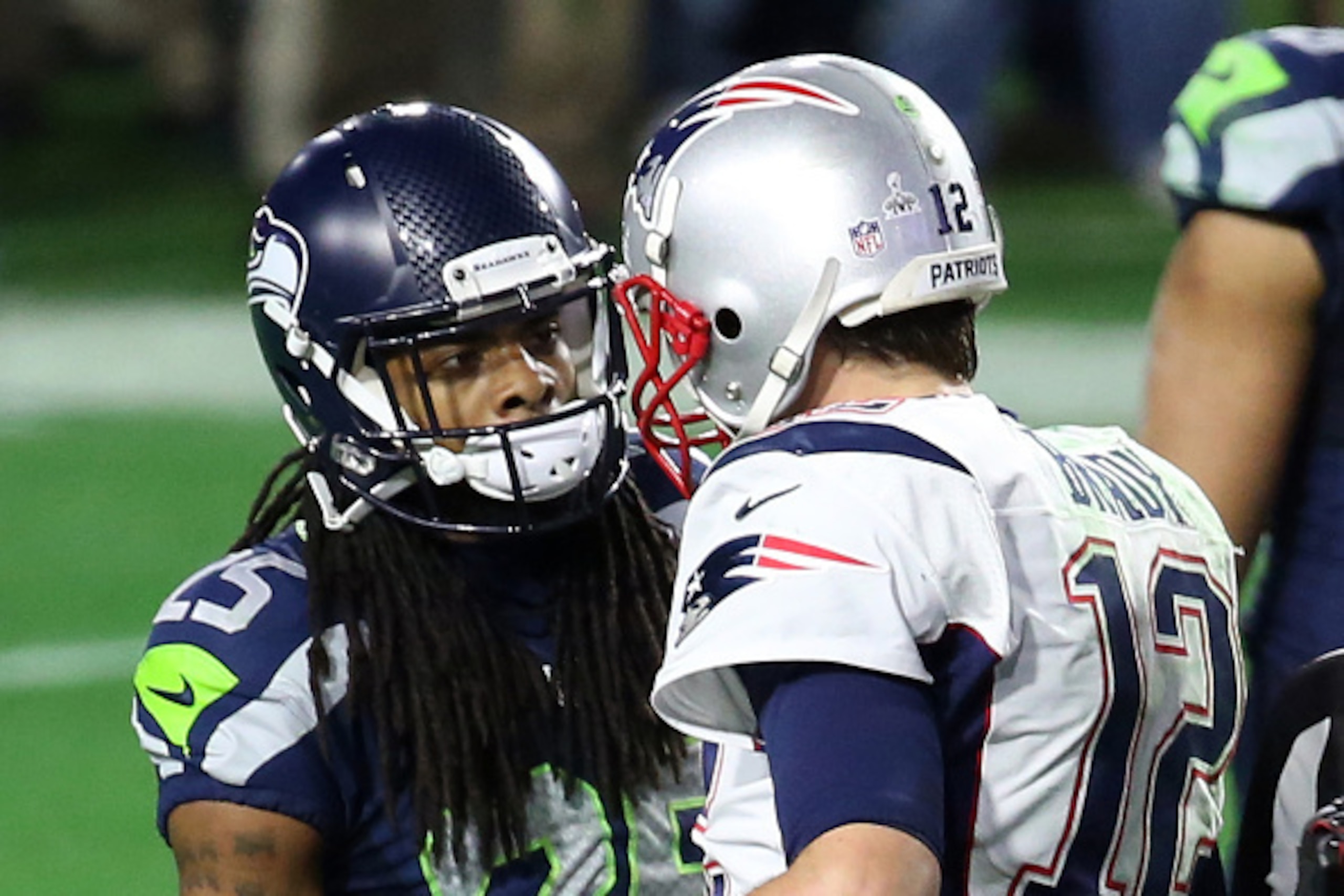 GLENDALE, AZ - FEBRUARY 01:  Richard Sherman #25 of the Seattle Seahawks and  Tom Brady #12 of the New England Patriots speak late in the fourth quarter during Super Bowl XLIX at University of Phoenix Stadium on February 1, 2015 in Glendale, Arizona.  (Ph