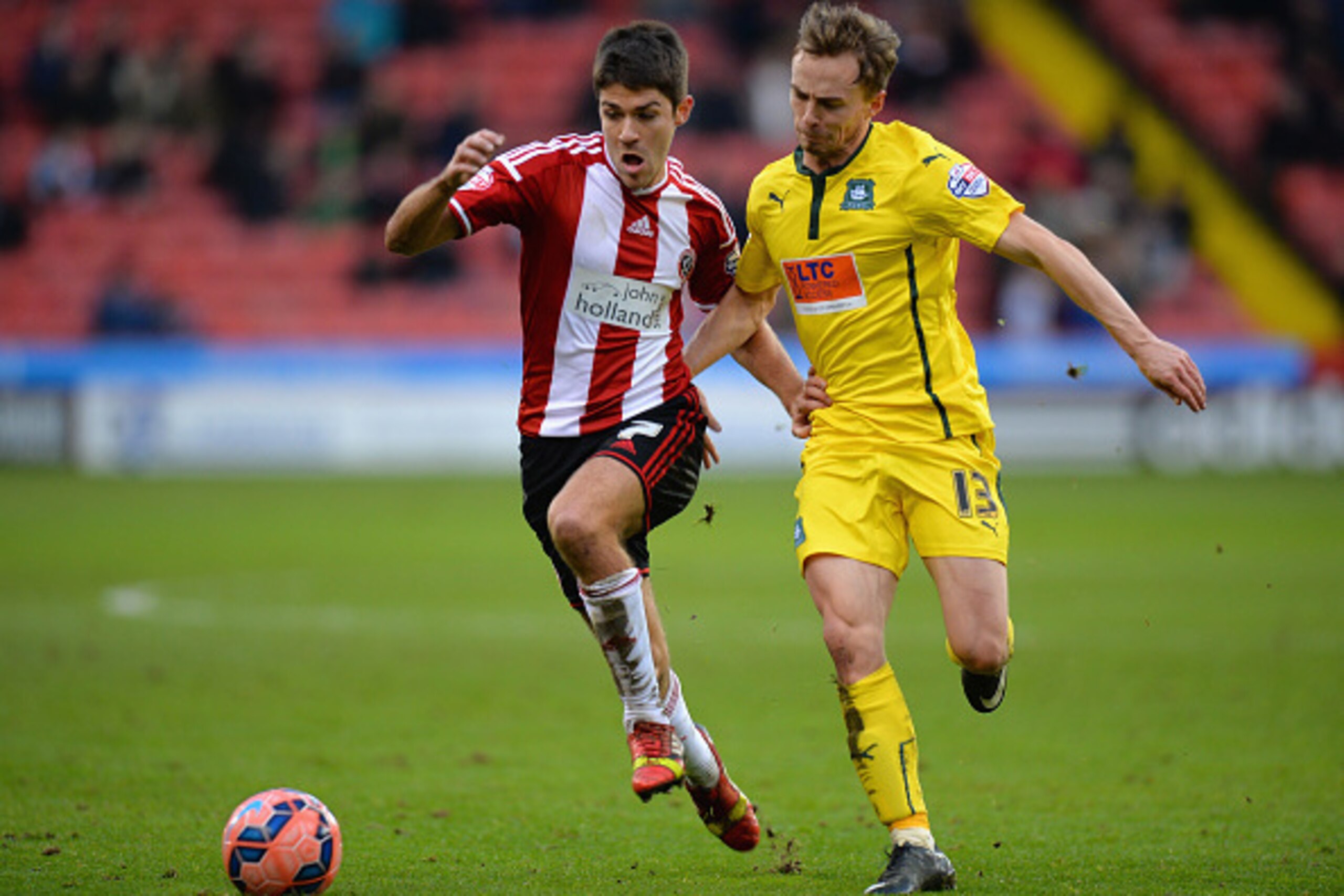 SHEFFIELD, ENGLAND - DECEMBER 06:  Ryan Flynn of Sheffield United is tackled by Andy Kellett of Plymouth Argyle during the FA Cup Second Round match between Sheffield United and Plymouth Argyle at Bramall Lane on December 6, 2014 in Sheffield, England.  (