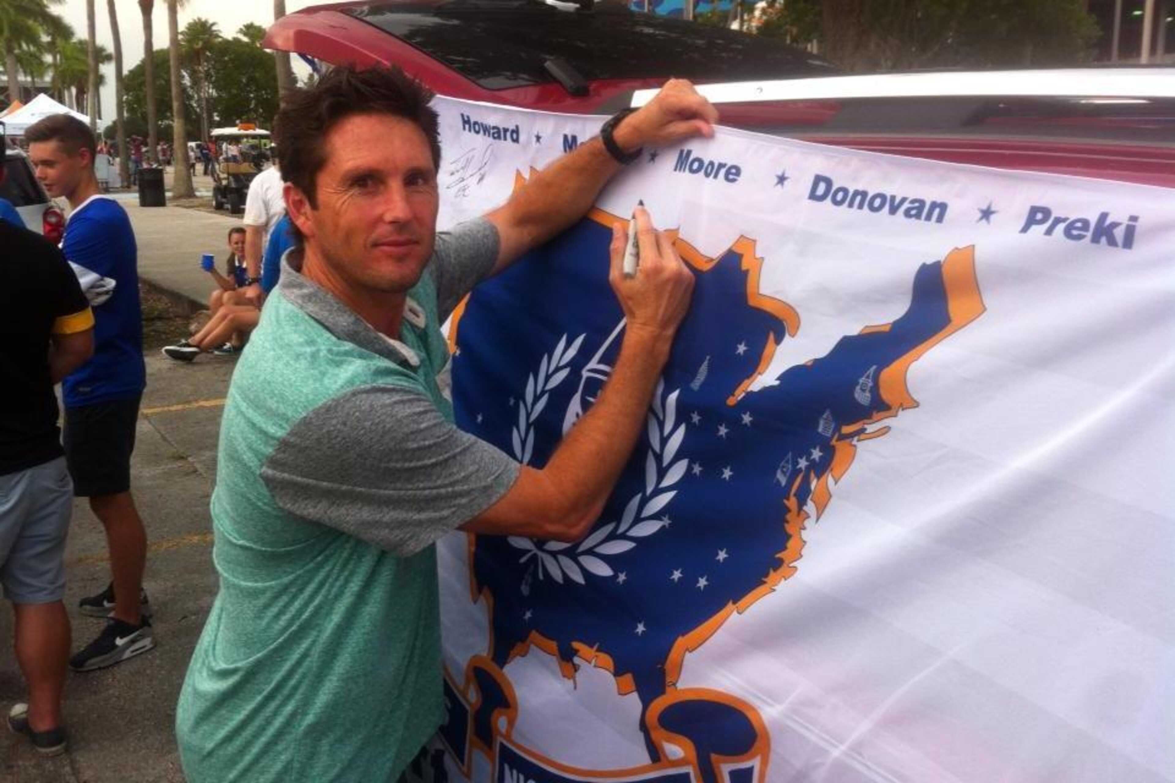 Joe-Max Moore signing a banner.
