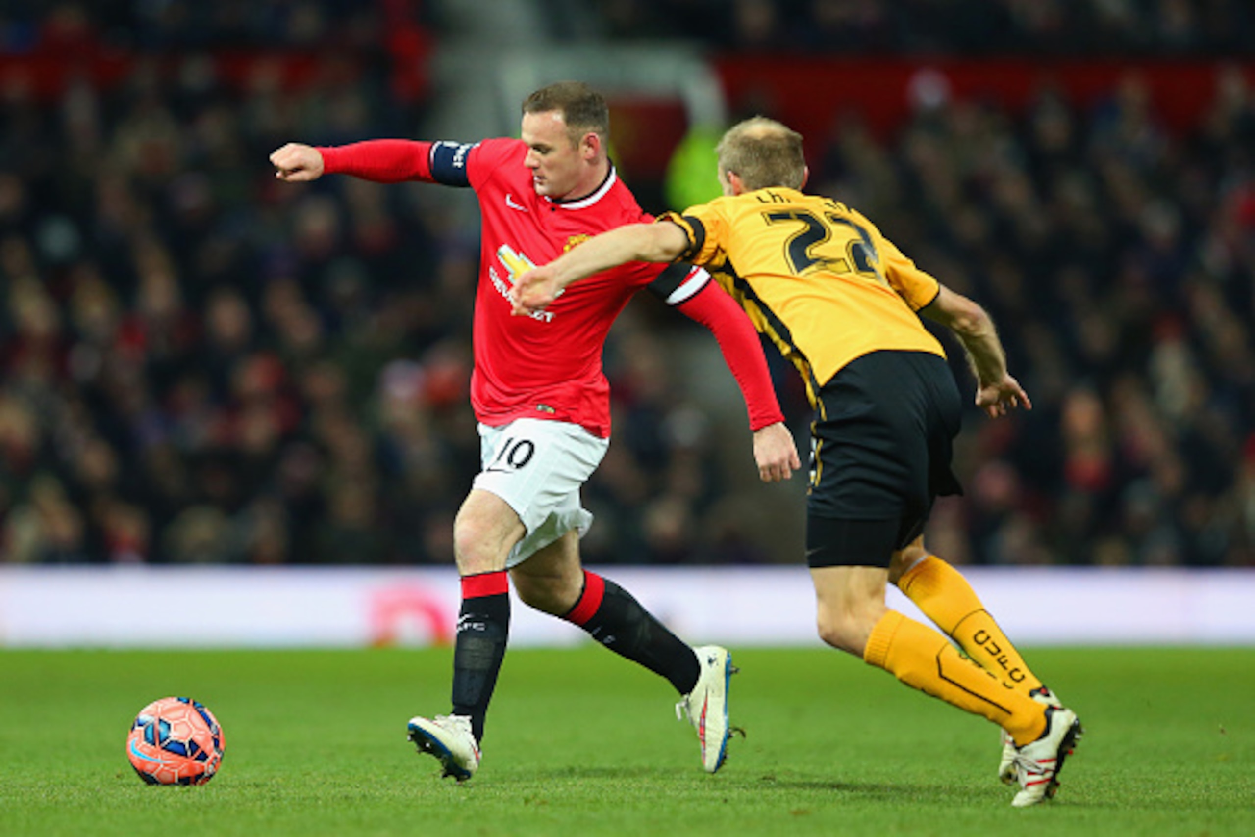 MANCHESTER, ENGLAND - FEBRUARY 03:  Wayne Rooney of Manchester United is closed down by Luke Chadwick of Cambridge United during the FA Cup Fourth round replay match between Manchester United and Cambridge United at Old Trafford on February 3, 2015 in Man