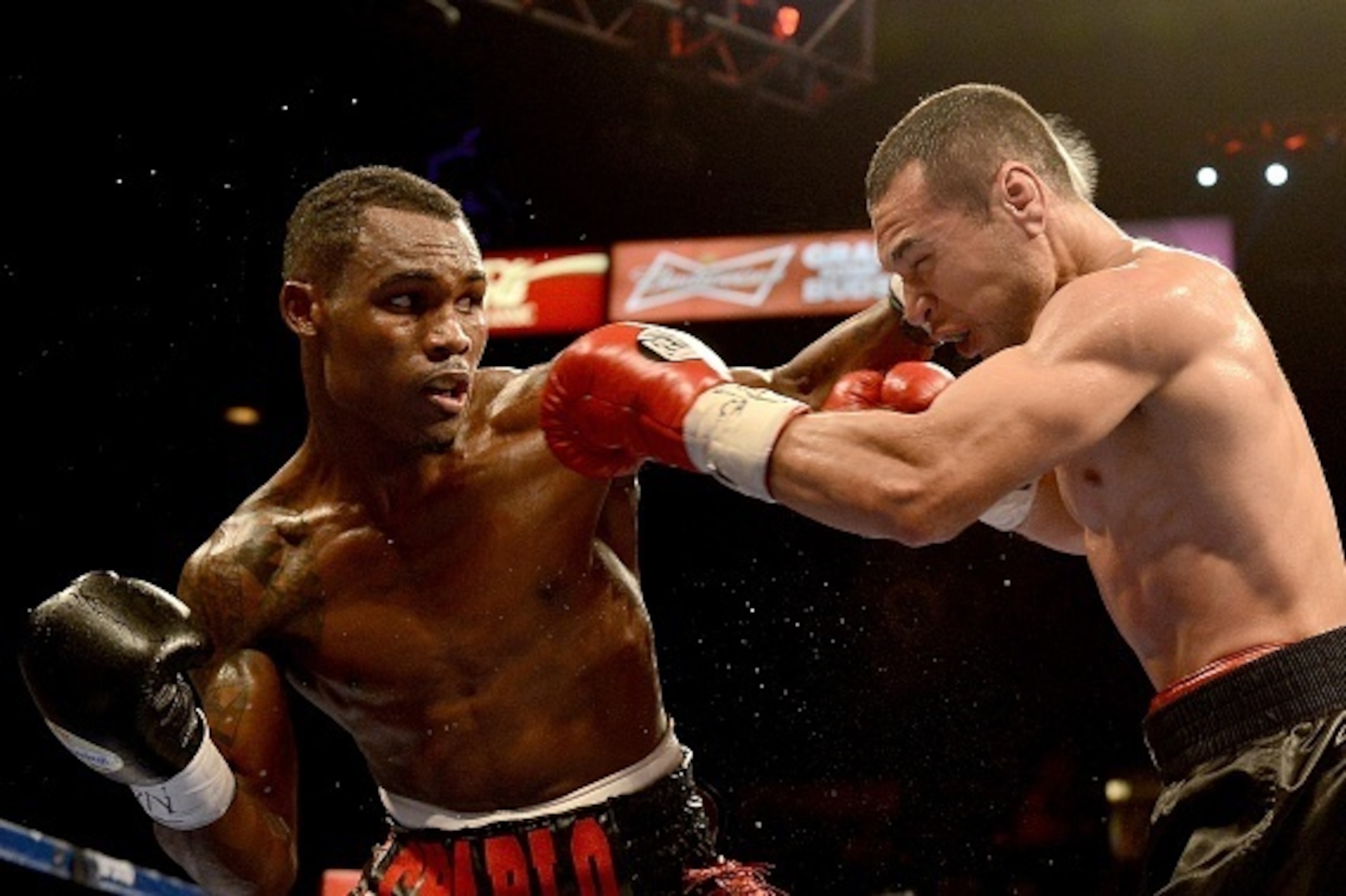 LAS VEGAS, NV-  DECEMBER 13:  Jermell Charlo (L) hits Mario Lozano during their junior welterweight fight at the MGM Grand Garden Arena on December 13, 2014 in Las Vegas, Nevada. Charlo won by unanimous decision after 10 rounds. (Photo by Donald Miralle/G
