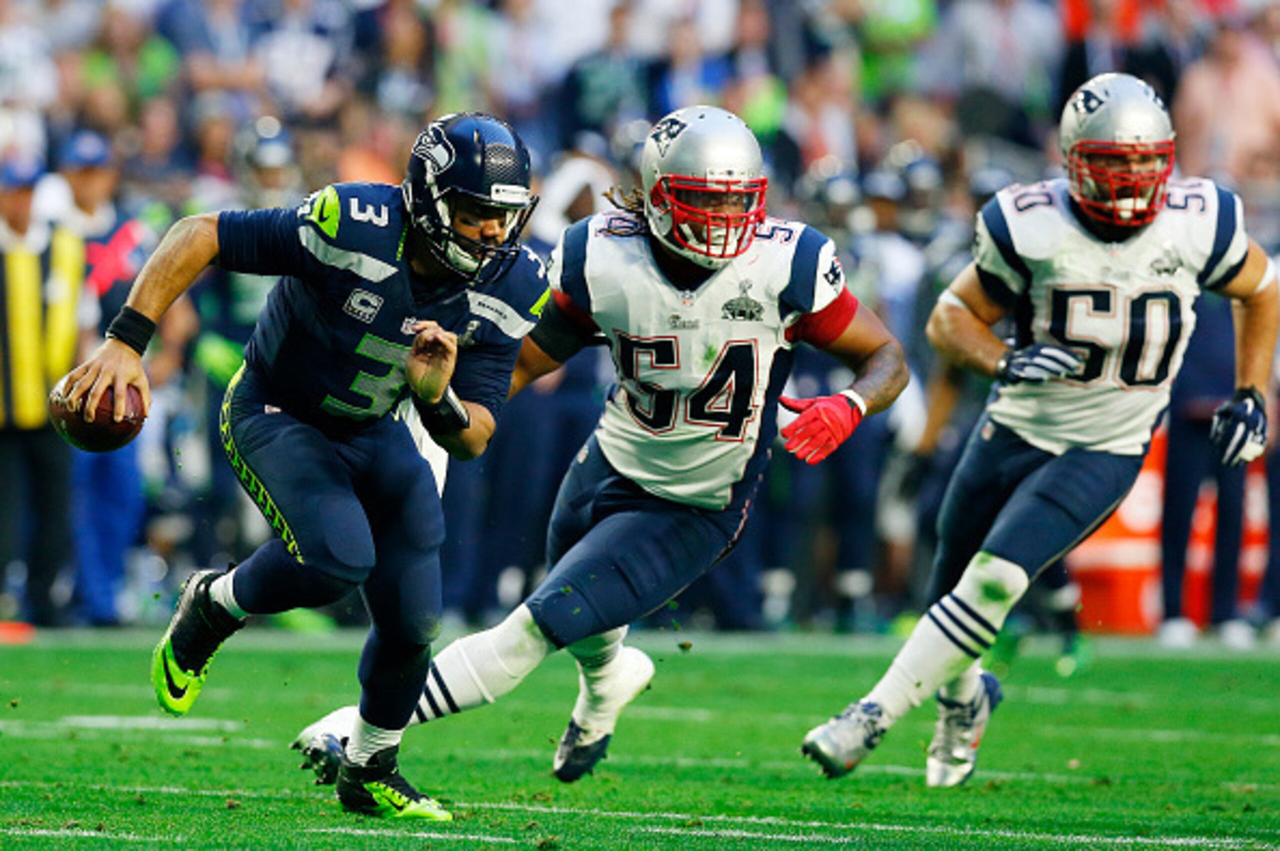 GLENDALE, AZ - FEBRUARY 01:  Russell Wilson #3 of the Seattle Seahawks  scrambles with the ball against Dont'a Hightower #54 of the New England Patriots  in the first quarter during Super Bowl XLIX at University of Phoenix Stadium on February 1, 2015 in G
