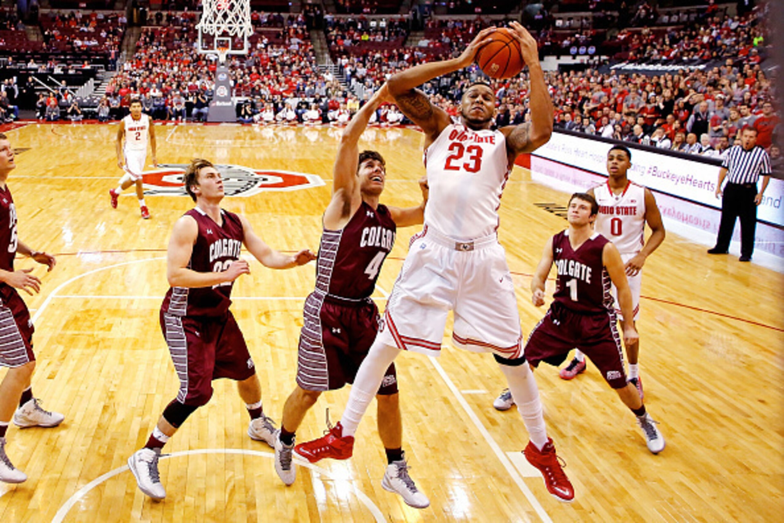 COLUMBUS, OH - DECEMBER 6:  Amir Williams #23 of the Ohio State Buckeyes grabs a rebound while being defended by Luke Roh #4 of the Colgate Raiders during the first half at Value City Arena on December 6, 2014 in Columbus, Ohio. Ohio State defeated Colgat