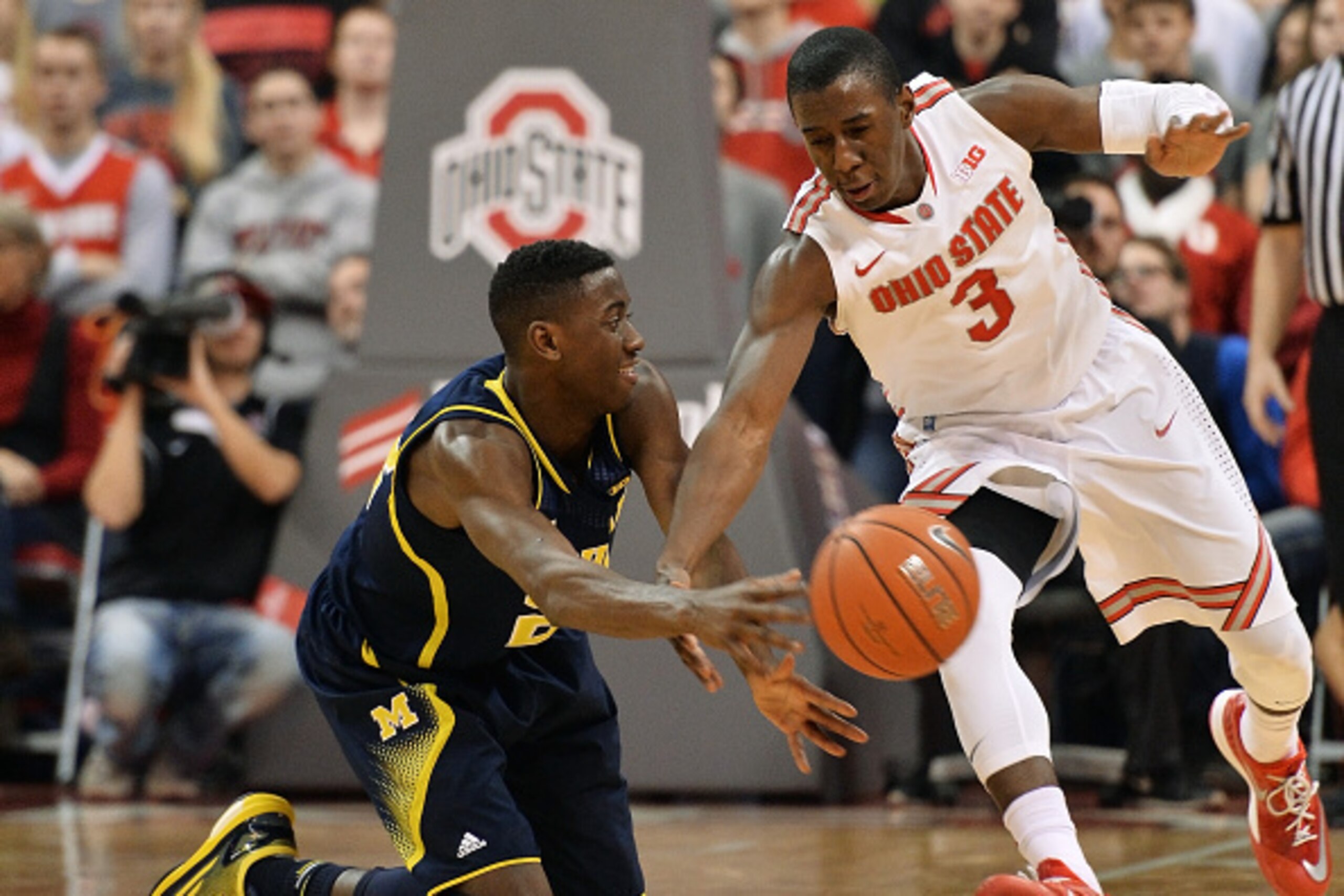 COLUMBUS, OH - JANUARY 13:  Caris LeVert #23 of the Michigan Wolverines passes off the ball before Shannon Scott #3 of the Ohio State Buckeyes can defend in the second half on January 13, 2015 at Value City Arena in Columbus, Ohio. Ohio State defeated Mic