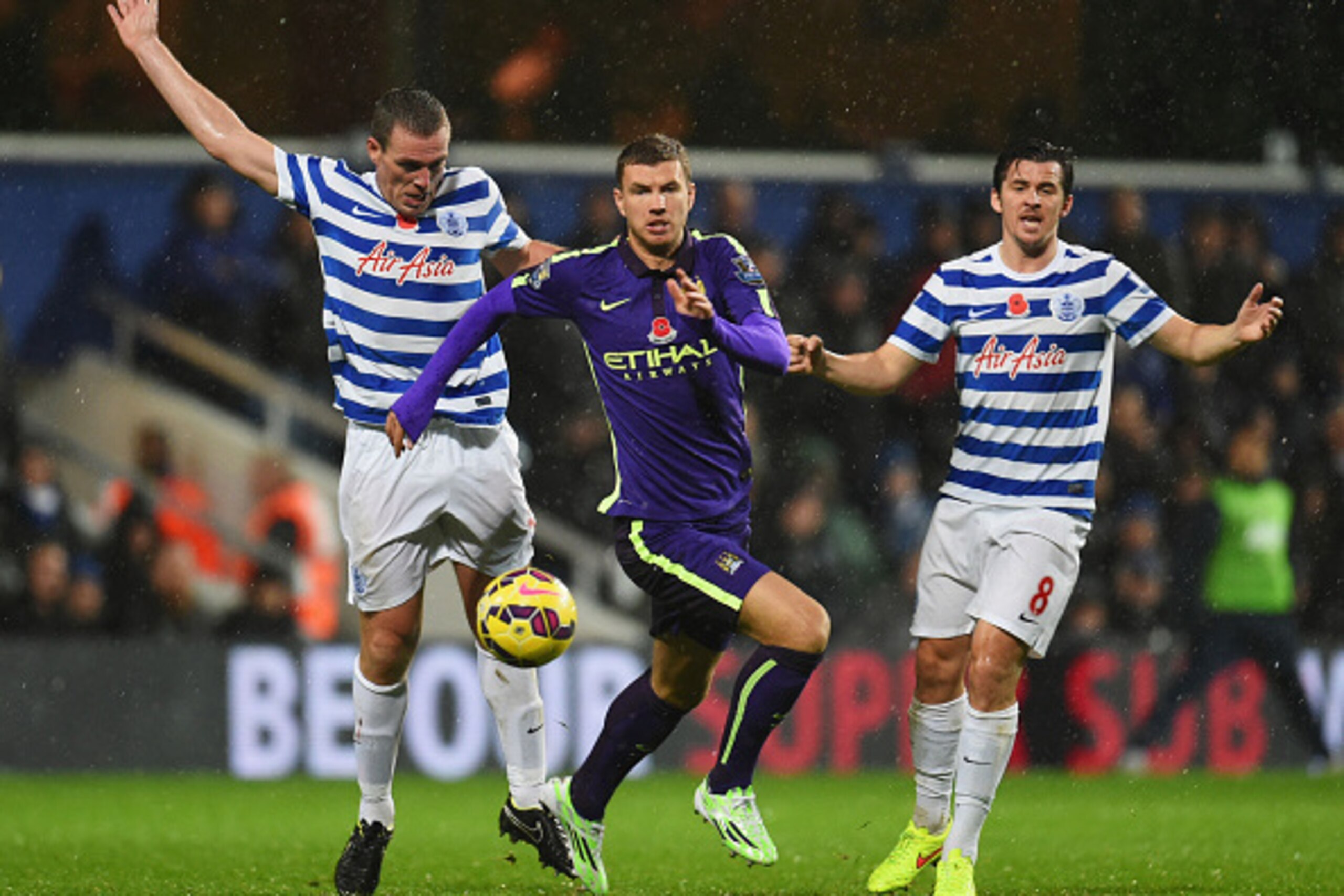 LONDON, ENGLAND - NOVEMBER 08:  Edin Dzeko of Manchester City evades Richard Dunne (L) and Joey Barton of QPR (R) during the Barclays Premier League match between Queens Park Rangers and Manchester City at Loftus Road on November 8, 2014 in London, Englan