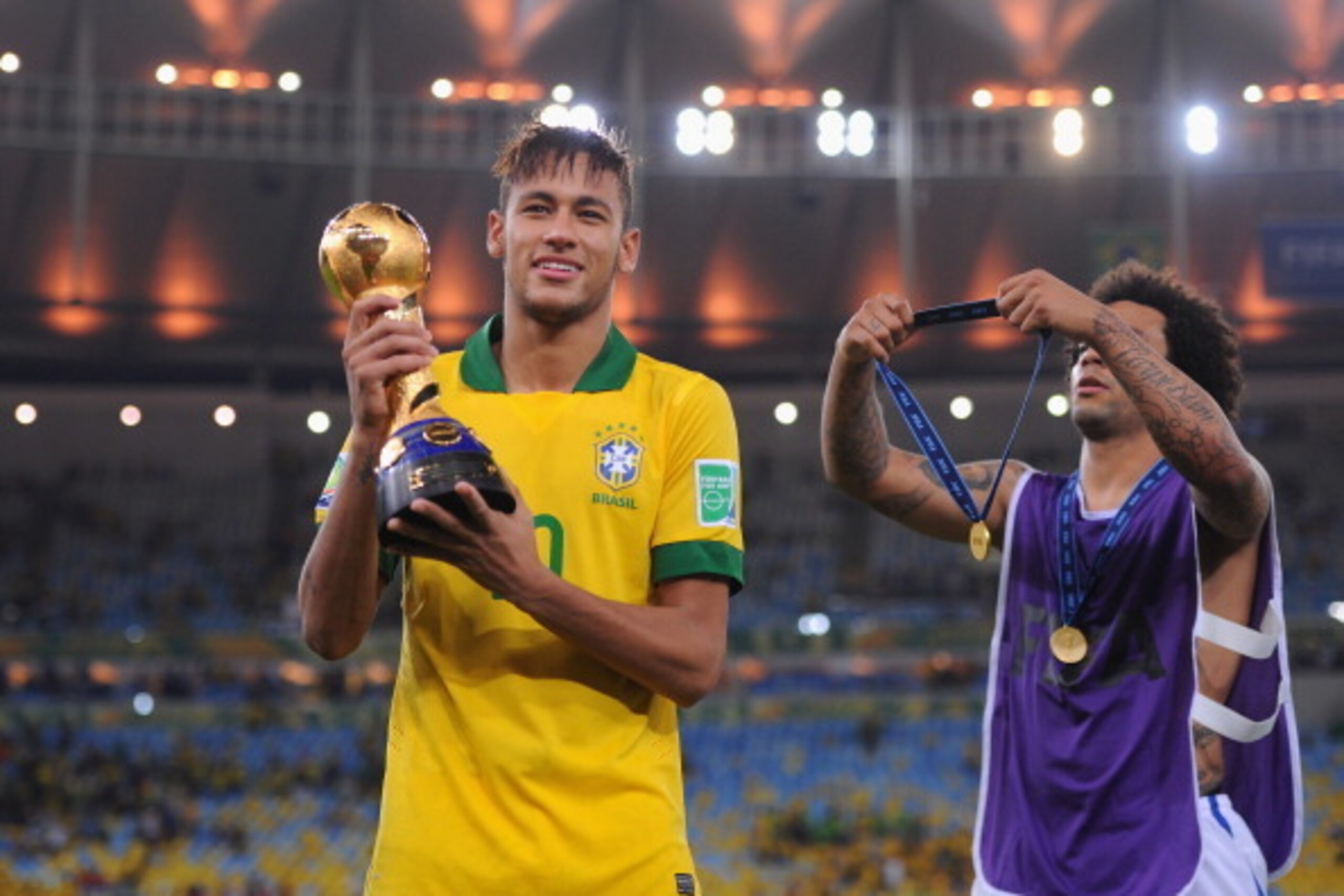 RIO DE JANEIRO, BRAZIL - JUNE 30:  Neymar of Brazil receives his medal from Marcelo at the end of the FIFA Confederations Cup Brazil 2013 Final match between Brazil and Spain at Maracana on June 30, 2013 in Rio de Janeiro, Brazil.  (Photo by Michael Regan