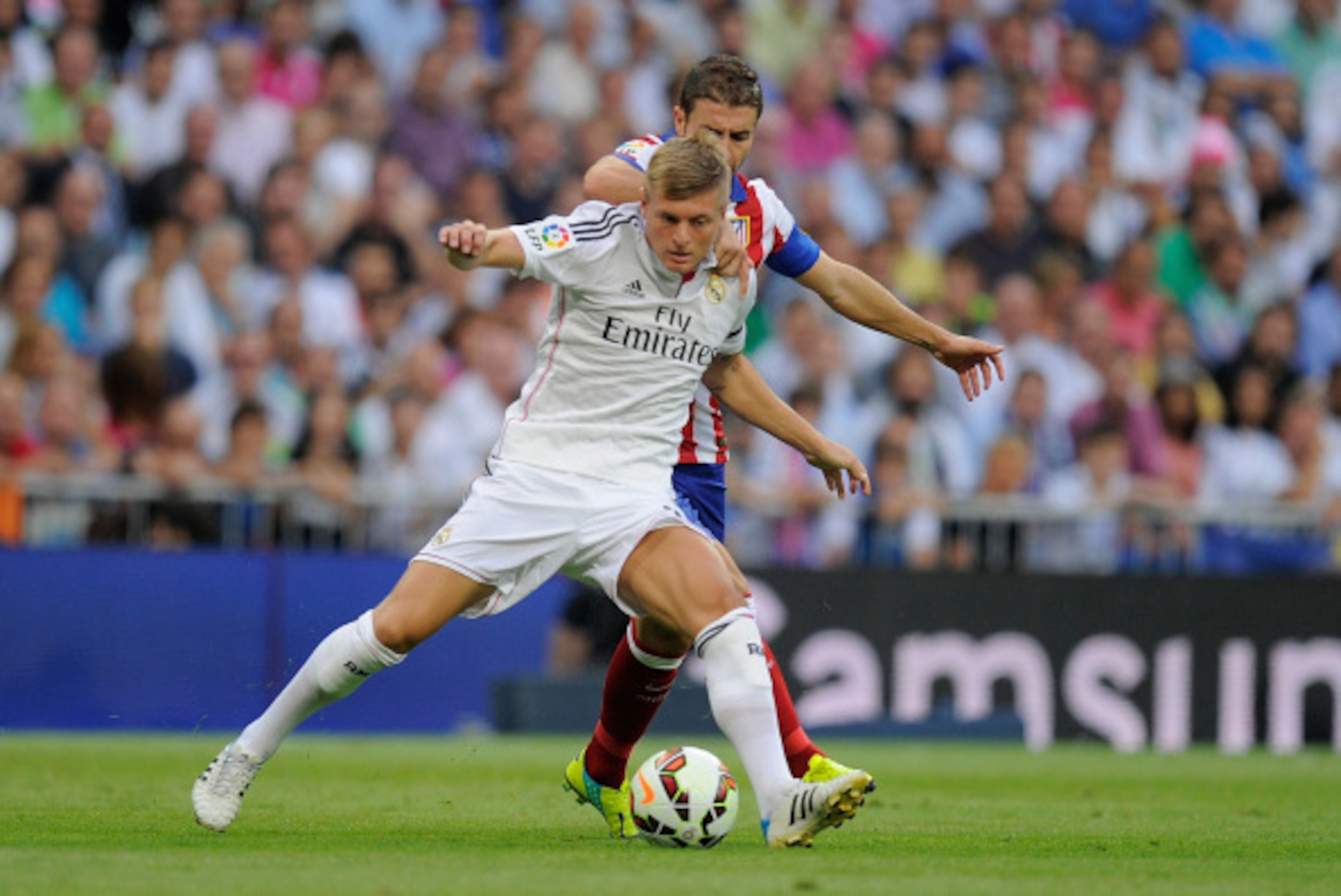 MADRID, SPAIN - SEPTEMBER 13:  Toni Kroos of Real Madrid battles for the ball against Gabi Fernandez of A tletico de Madrid during the La Liga match between Real Madrid and Atletico de Madrid at Estadio Santiago Bernabeu on September 13, 2014 in Madrid, S