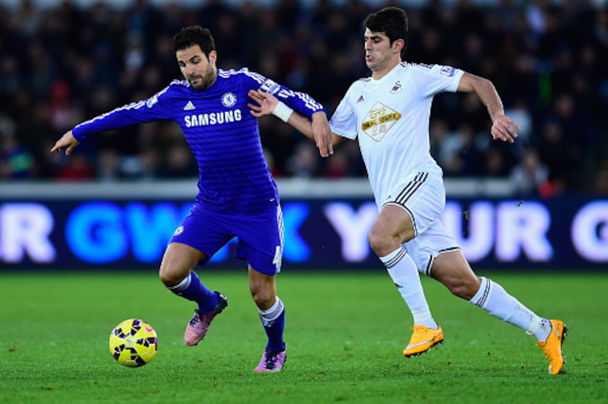 SWANSEA, WALES - JANUARY 17: Chelsea player Cesc Fabregas (l) is challenged by Nelson Oliveira of Swansea during the Barclays Premier League match between Swansea City and Chelsea at Liberty Stadium on January 17, 2015 in Swansea, Wales. (Photo by Stu F SWANSEA, WALES - JANUARY 17: Chelsea player Cesc Fabregas (l) is challenged by Nelson Oliveira of Swansea during the Barclays Premier League match between Swansea City and Chelsea at Liberty Stadium on January 17, 2015 in Swansea, Wales. (Photo by Stu F