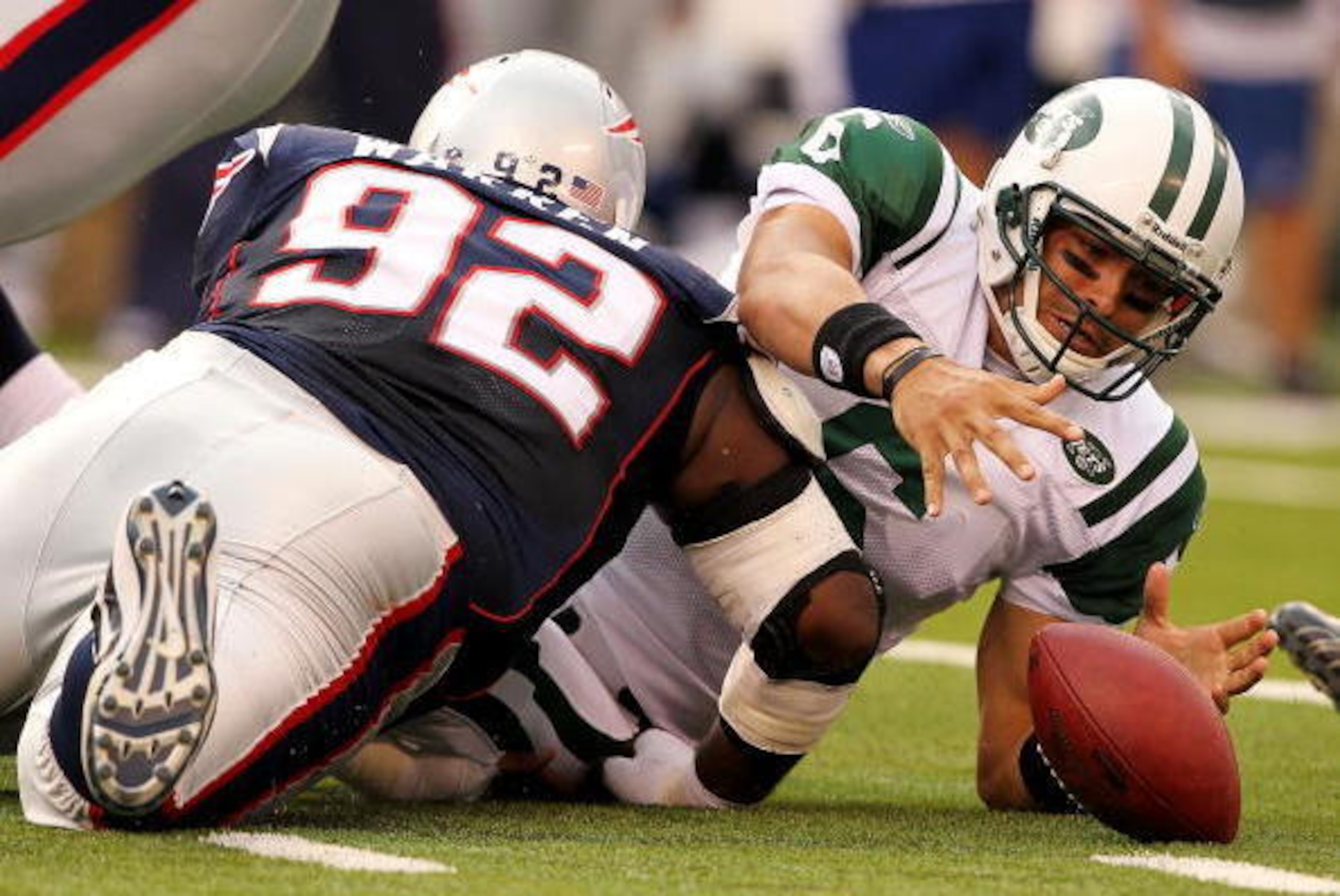 EAST RUTHERFORD, NJ - SEPTEMBER 19:  Mark Sanchez #6  of the New York Jets fumbles the ball after being sacked by Gerard Warren #92 of the New England Patriots during their  game on September 19, 2010 at the New Meadowlands Stadium  in East Rutherford, Ne