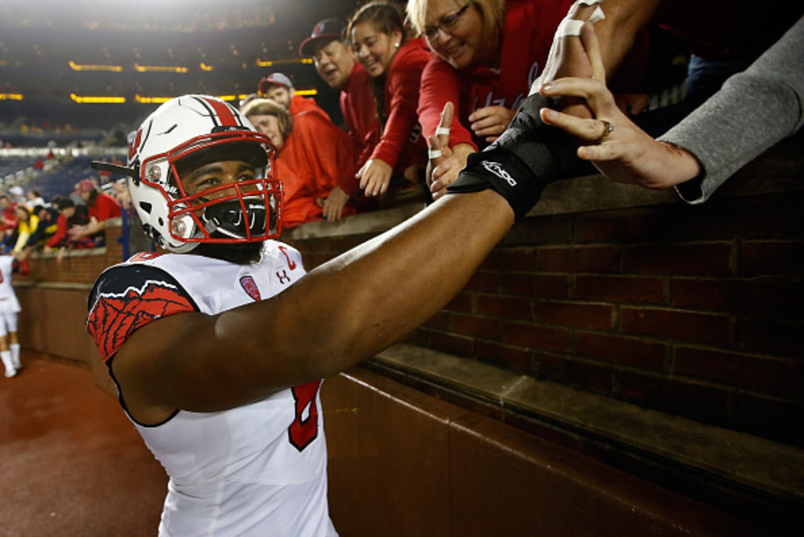 ANN ARBOR, MI - SEPTEMBER 20:  Nate Orchard #8 of the Utah Utes high fives fans fans after a 26-10 win over the Michigan Wolverines on September 20, 2014 at Michigan Stadium in Ann Arbor, Michigan.  (Photo by Gregory Shamus/Getty Images)