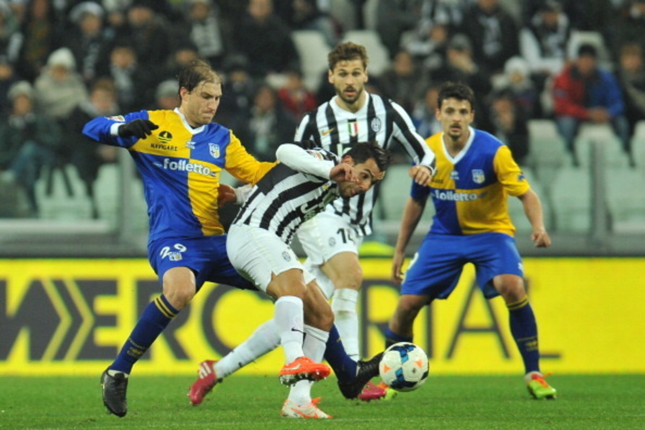 TURIN, ITALY - MARCH 26:  Carlos Tevez (R) of Juventus is tackled by Gabriel Alejandro Paletta of Parma FC during the serie A match between Juventus and Parma FC at Juventus Arena on March 26, 2014 in Turin, Italy.  (Photo by Valerio Pennicino/Getty Image