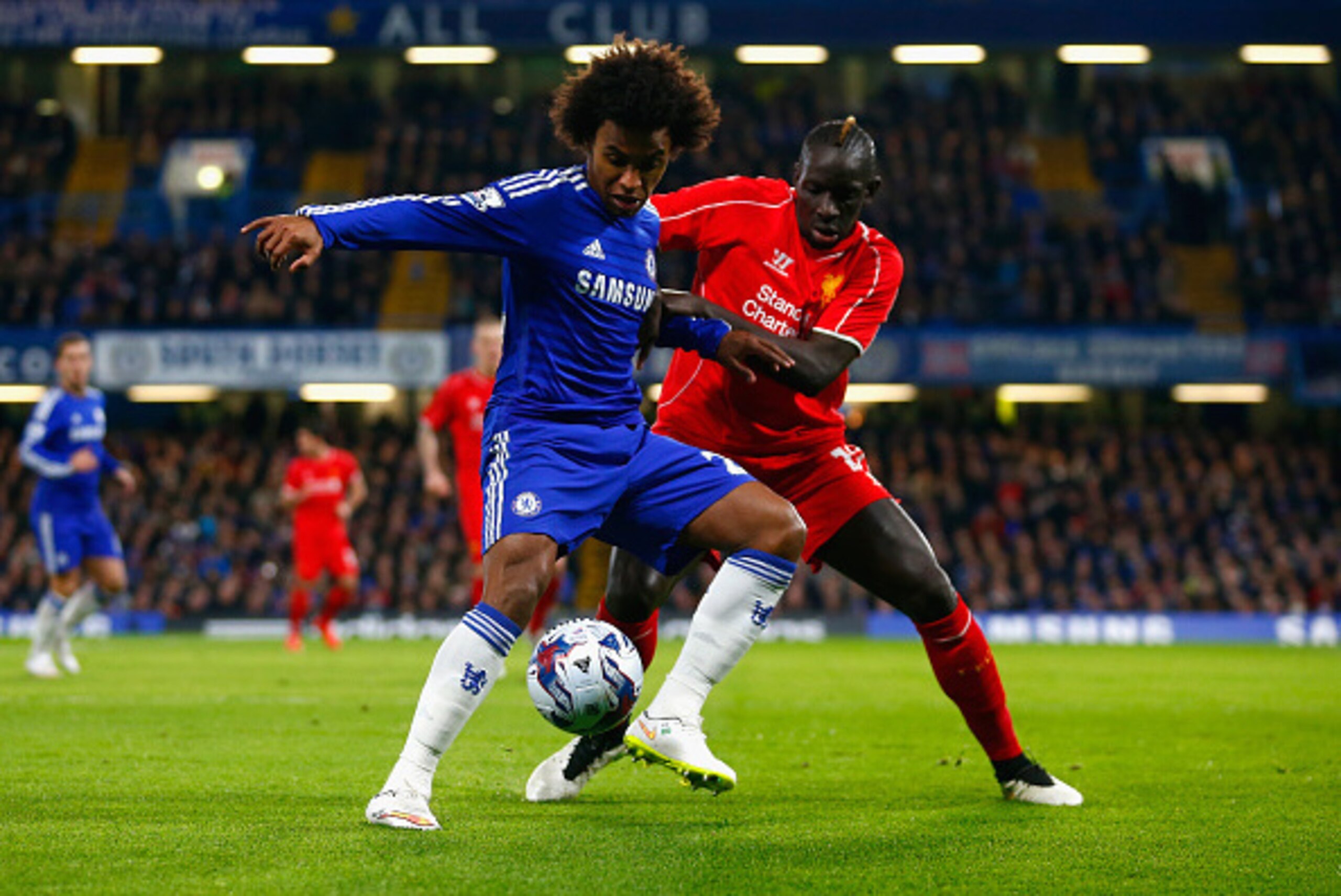 LONDON, ENGLAND - JANUARY 27: Willian of Chelsea is marshalled by Mamadou Sakho of Liverpool during the Capital One Cup Semi-Final second leg between Chelsea and Liverpool at Stamford Bridge on January 27, 2015 in London, England. (Photo by Julian Finn LONDON, ENGLAND - JANUARY 27: Willian of Chelsea is marshalled by Mamadou Sakho of Liverpool during the Capital One Cup Semi-Final second leg between Chelsea and Liverpool at Stamford Bridge on January 27, 2015 in London, England. (Photo by Julian Finn