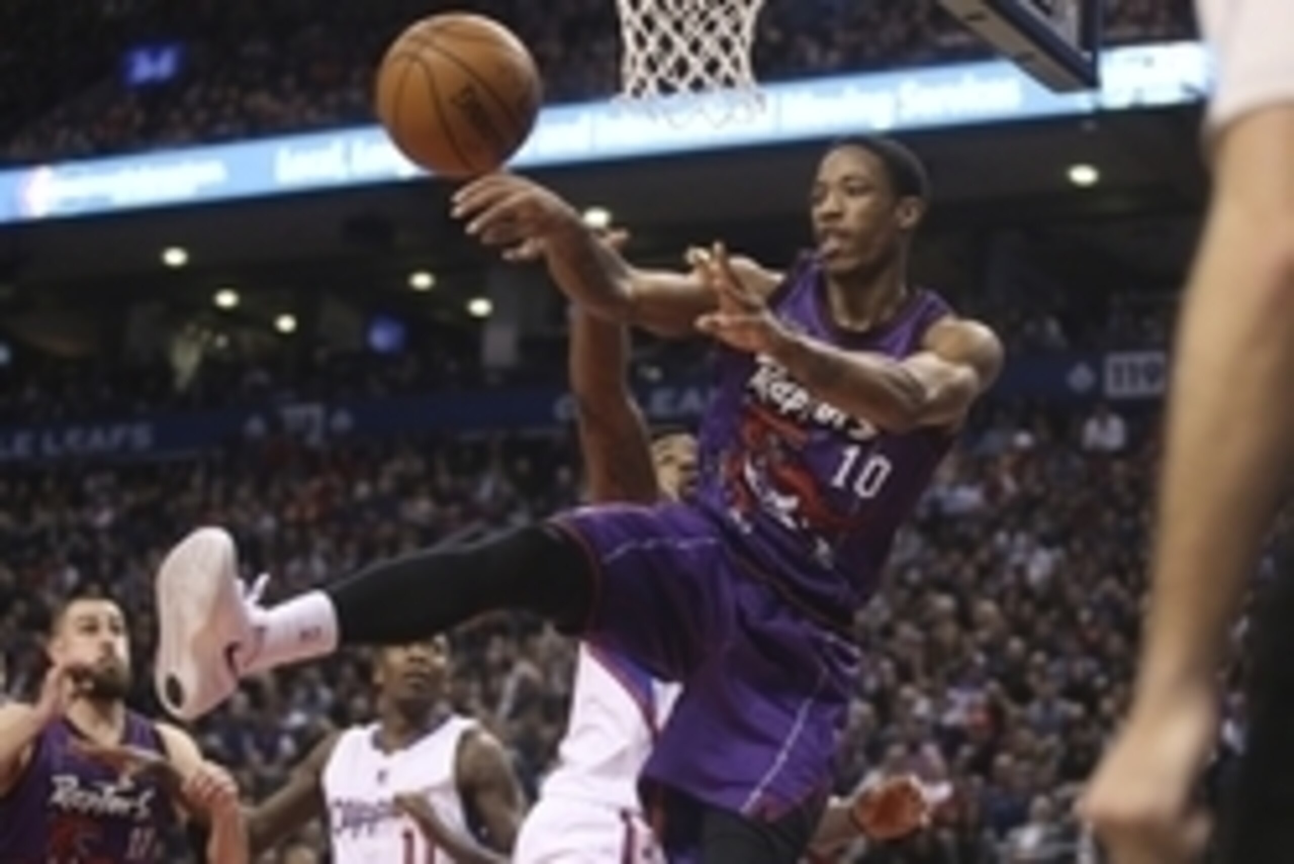 Feb 6, 2015; Toronto, Ontario, CAN; Toronto Raptors guard DeMar DeRozan (10) passes the ball under the hoop as he is guarded by Los Angeles Clippers center DeAndre Jordan (6) at Air Canada Centre. The Raptors beat the Clippers 123-107. Mandatory Credit: T