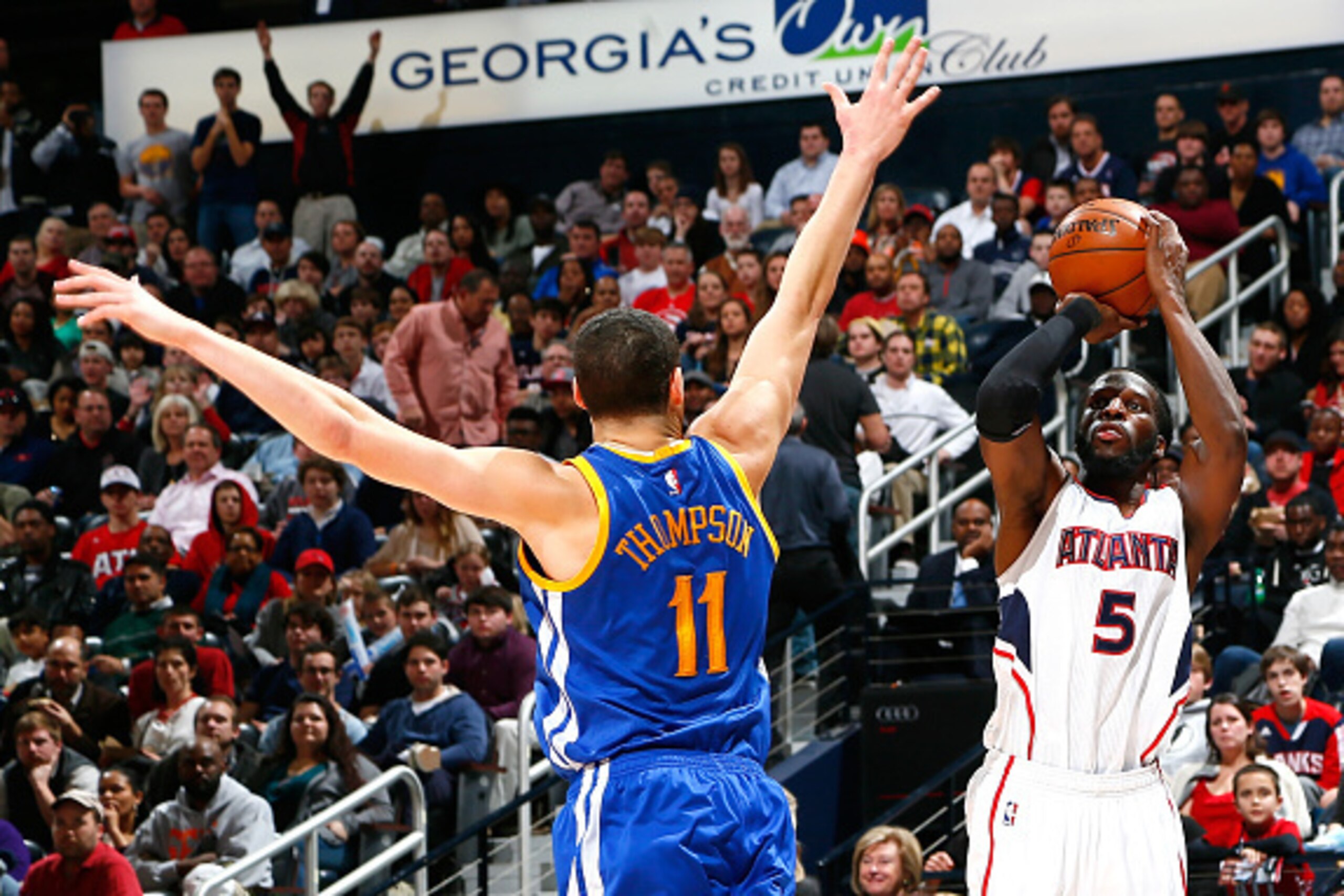 ATLANTA, GA - FEBRUARY 06:  DeMarre Carroll #5 of the Atlanta Hawks shoots a three-point basket against Klay Thompson #11 of the Golden State Warriors at Philips Arena on February 6, 2015 in Atlanta, Georgia.  NOTE TO USER: User expressly acknowledges and
