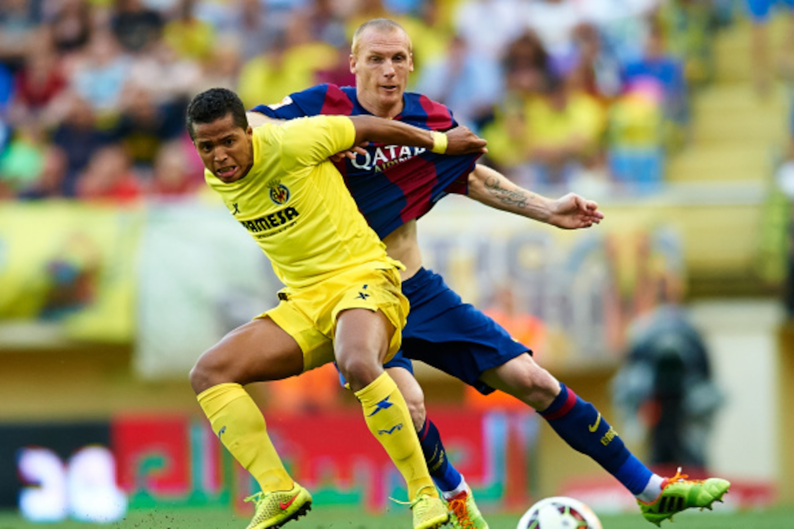 VILLARREAL, SPAIN - AUGUST 31: Giovani Dos Santos (L) of Villarreal competes for the ball with Mathieu of Barcelona during the La Liga match between Villarreal CF and FC Barcelona at El Madrigal stadium on August 31, 2014 in Villarreal, Spain. (Photo by VILLARREAL, SPAIN - AUGUST 31: Giovani Dos Santos (L) of Villarreal competes for the ball with Mathieu of Barcelona during the La Liga match between Villarreal CF and FC Barcelona at El Madrigal stadium on August 31, 2014 in Villarreal, Spain. (Photo by
