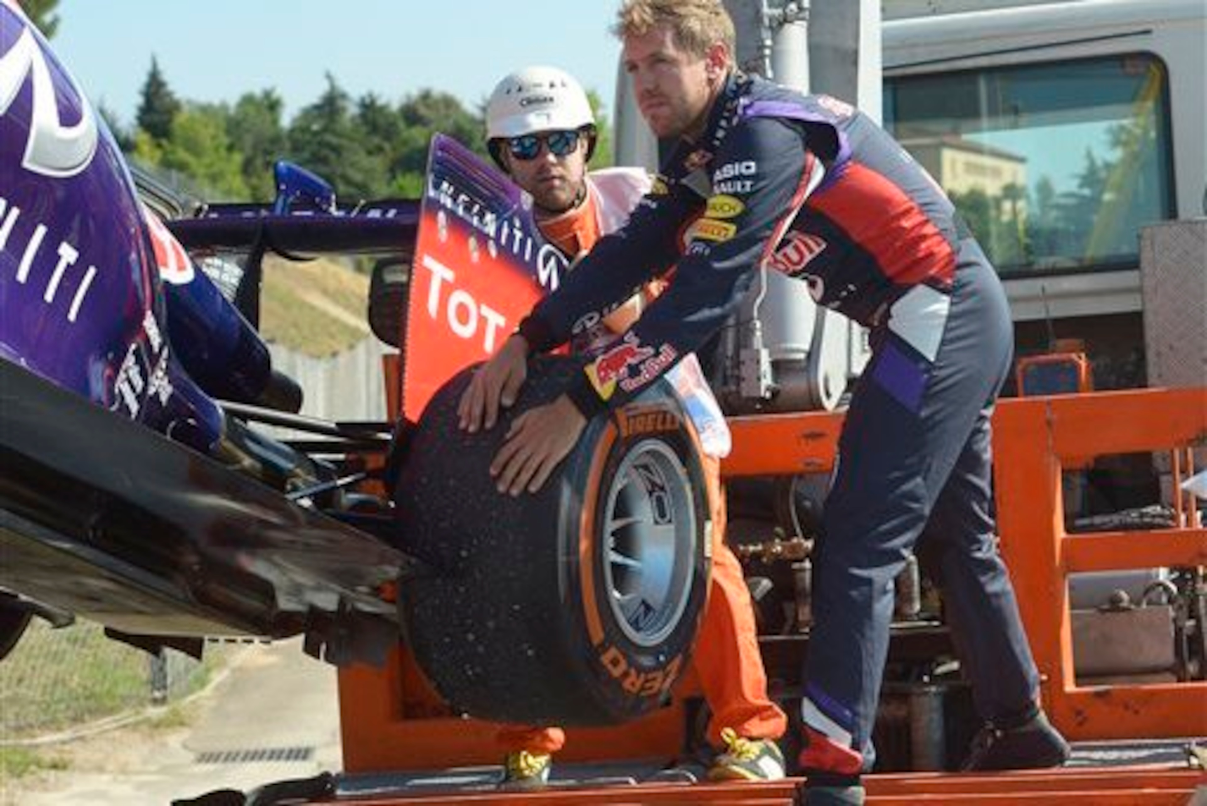 Sebastian Vettel helps out after his RB10 broke down in Spain.