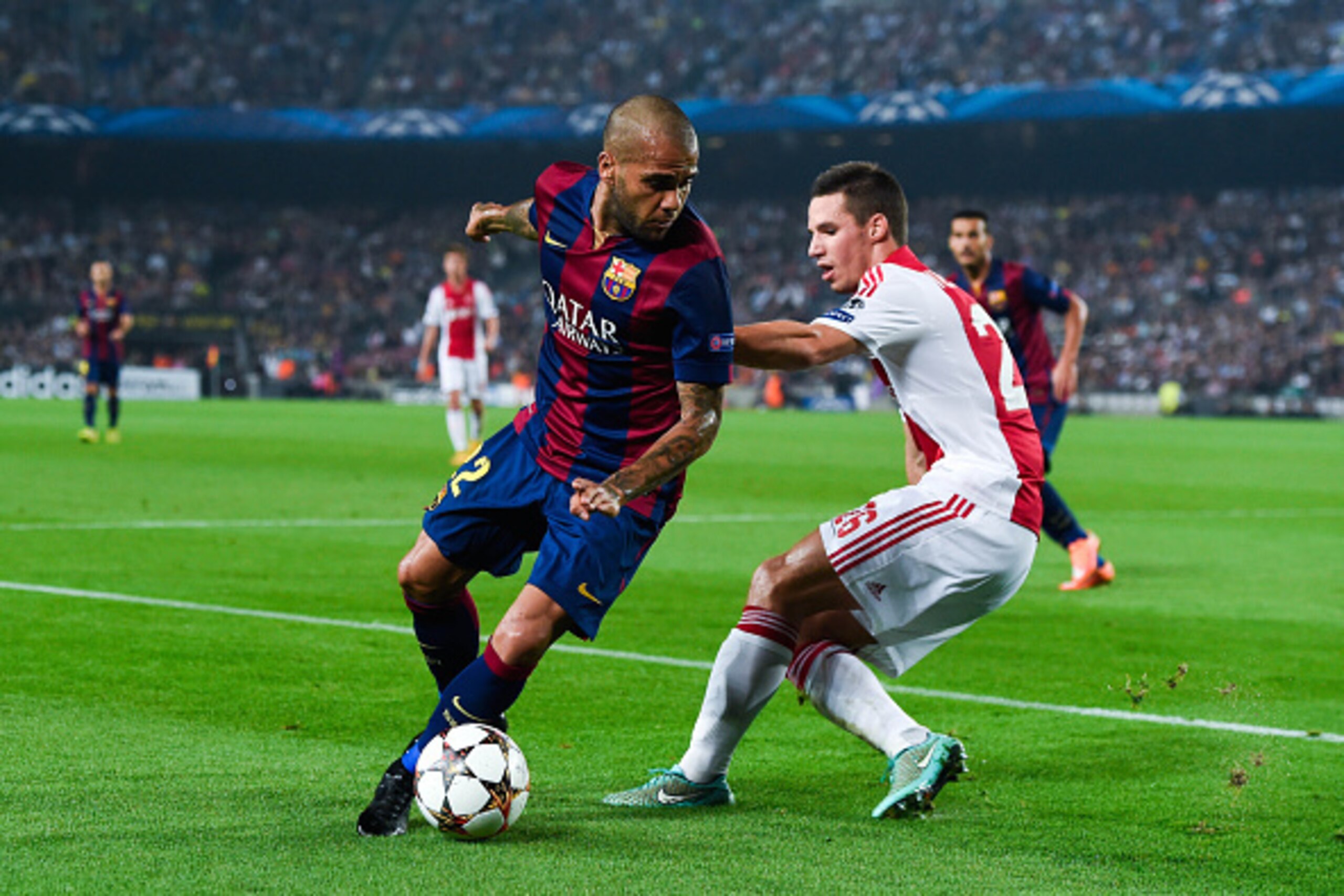 BARCELONA, SPAIN - OCTOBER 21:  Dani Alves of FC Barcelona competes for the ball with Nick Viergever of AFC Ajax during a UEFA Champions League Group F match between FC Barcelona and AFC Ajax at the Camp Nou Stadium on October 21, 2014 in Barcelona, Spain