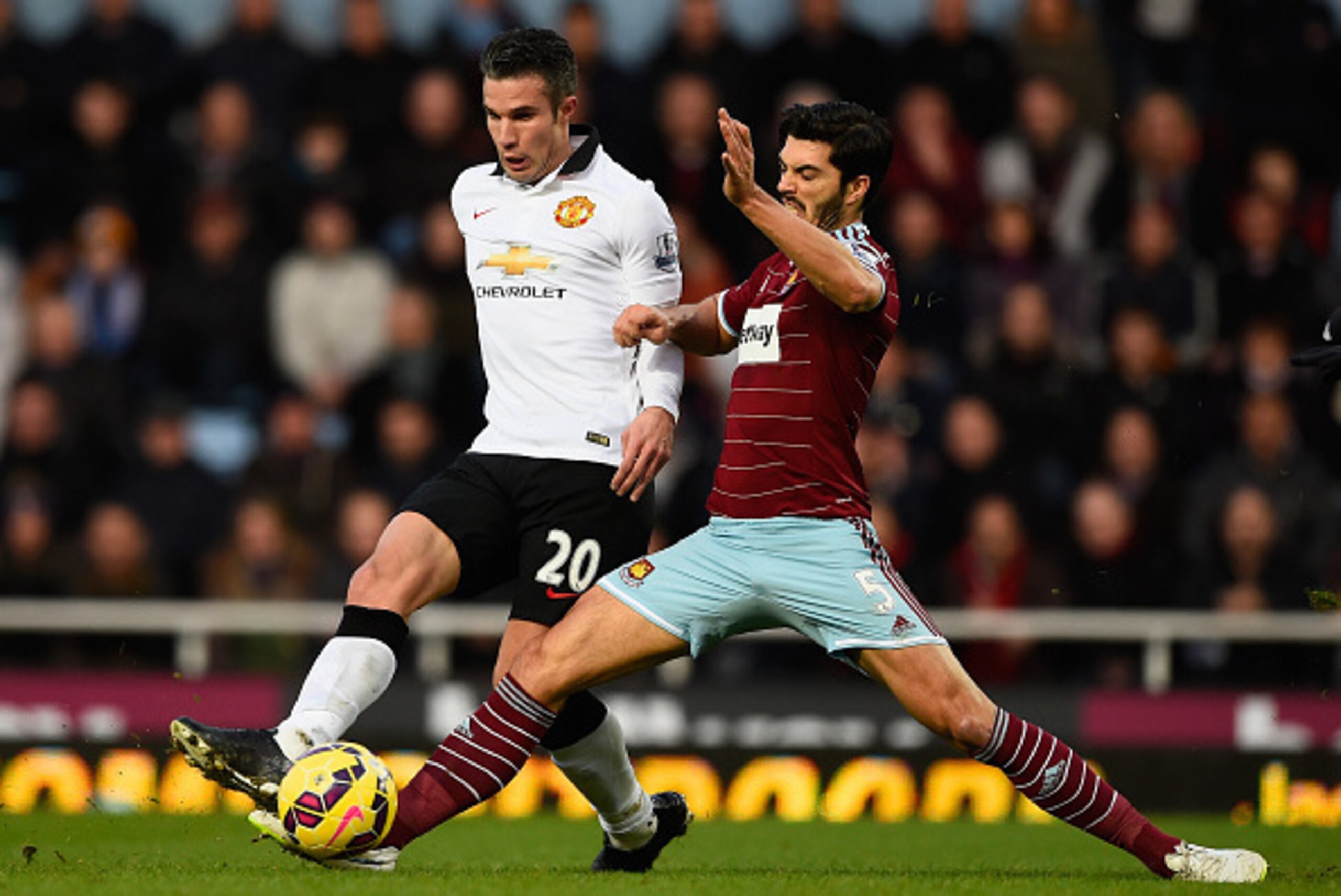 LONDON, ENGLAND - FEBRUARY 08:  James Tomkins of West Ham tackles Robin van Persie of Manchester United during the Barclays Premier League match between West Ham United and Manchester United at Boleyn Ground on February 8, 2015 in London, England.  (Photo