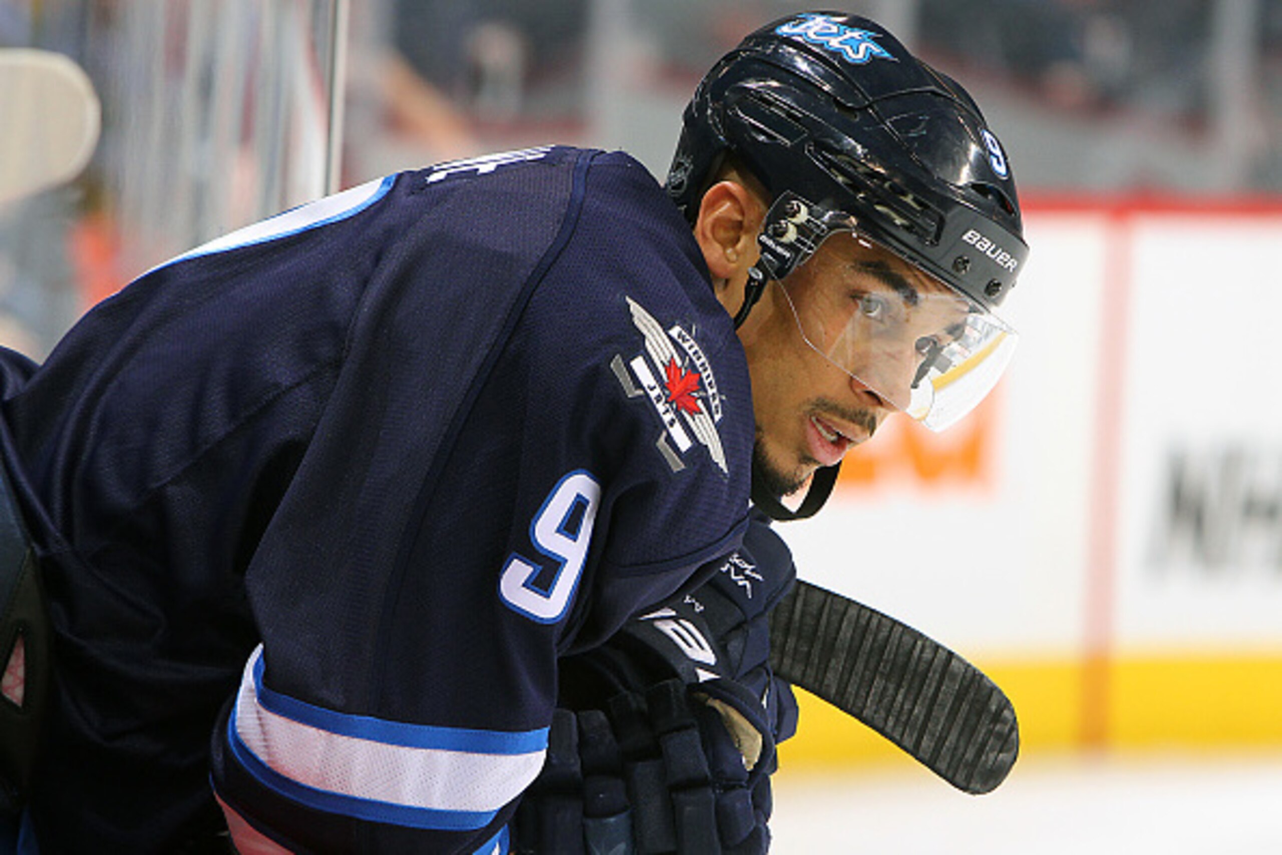 WINNIPEG, CANADA - JANUARY 18: Evander Kane #9 of the Winnipeg Jets leans over the bench as he looks on during second period action against the Arizona Coyotes on January 18, 2015 at the MTS Centre in Winnipeg, Manitoba, Canada.  (Photo by Jonathan Kozub/
