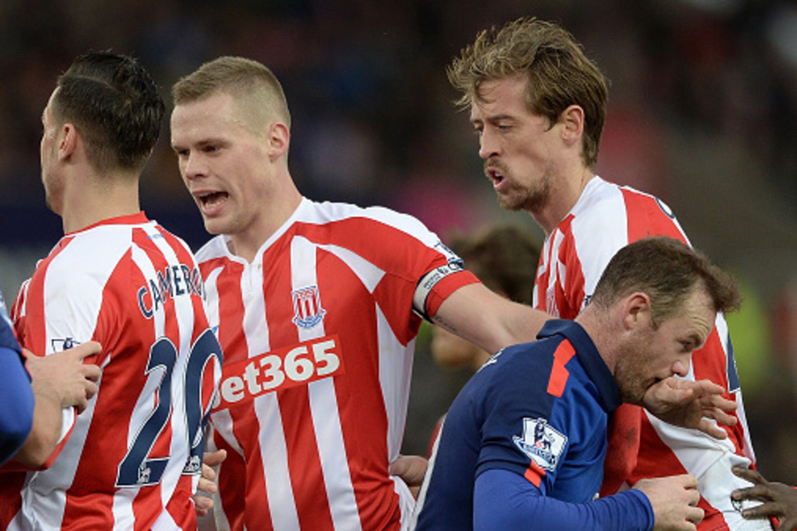 STOKE ON TRENT, ENGLAND - JANUARY 01:  Wayne Rooney of Manchester United tangles with Ryan Shawcross and Peter Crouch of Stoke City during the Barclays Premier League match between Stoke City and Manchester United at Britannia Stadium on January 1, 2015 i