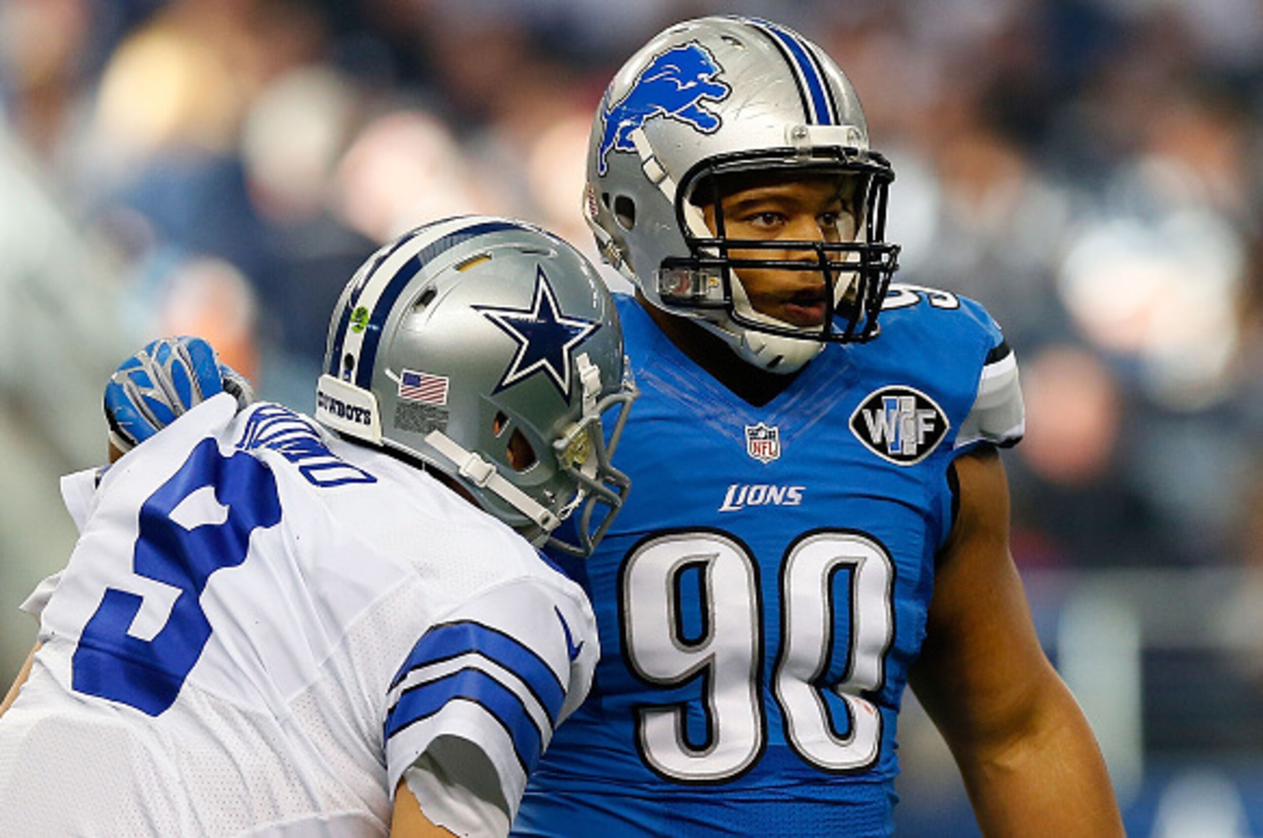 ARLINGTON, TX - JANUARY 04:  Ndamukong Suh #90 of the Detroit Lions  helps Tony Romo #9 of the Dallas Cowboys to his feet during the first half of their NFC Wild Card Playoff game at AT&T Stadium on January 4, 2015 in Arlington, Texas.  (Photo by Tom Penn